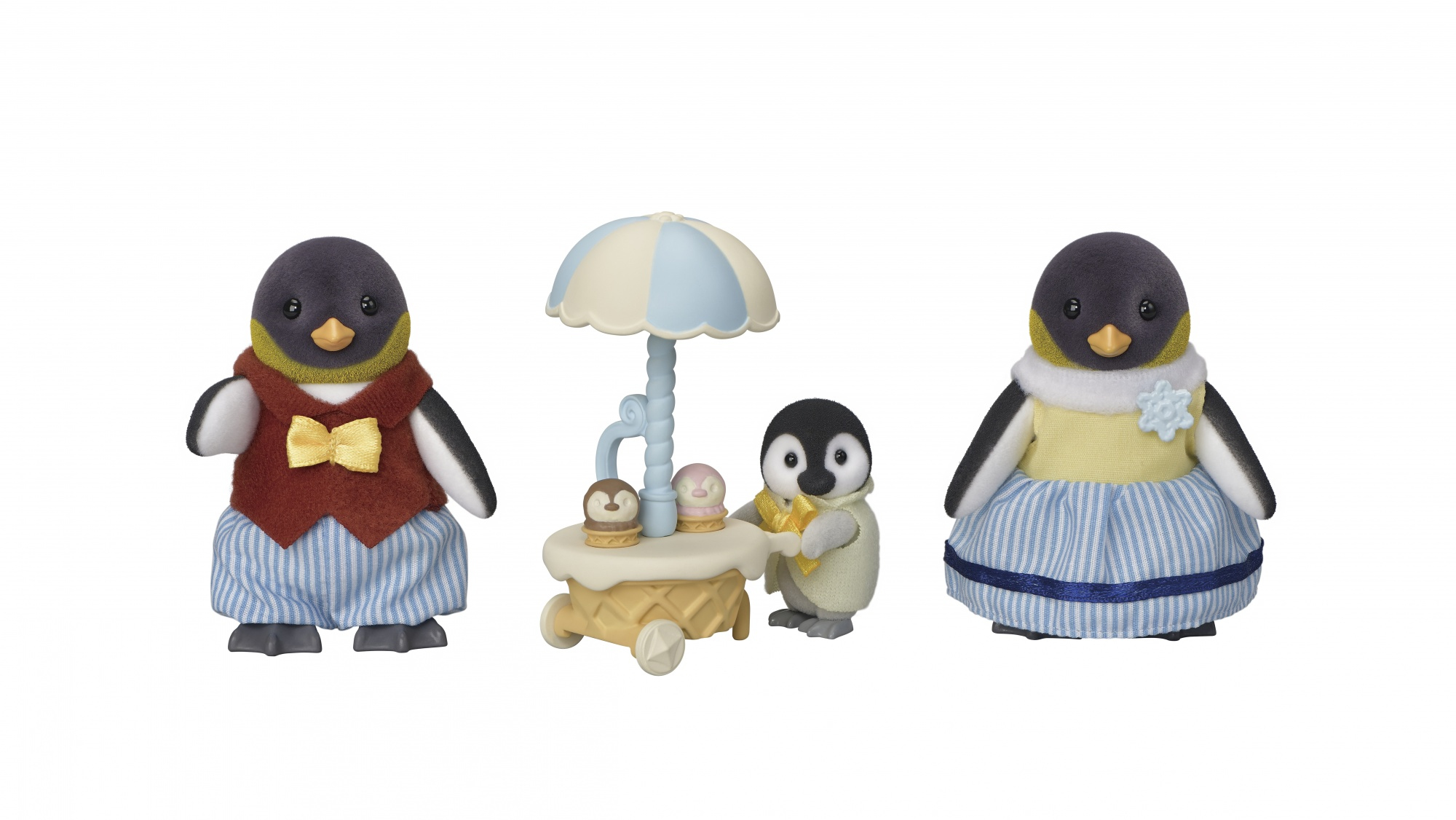 Tres figuras de pingüinos. Uno lleva chaleco y pajarita, otro vende helados y el último lleva un vestido.