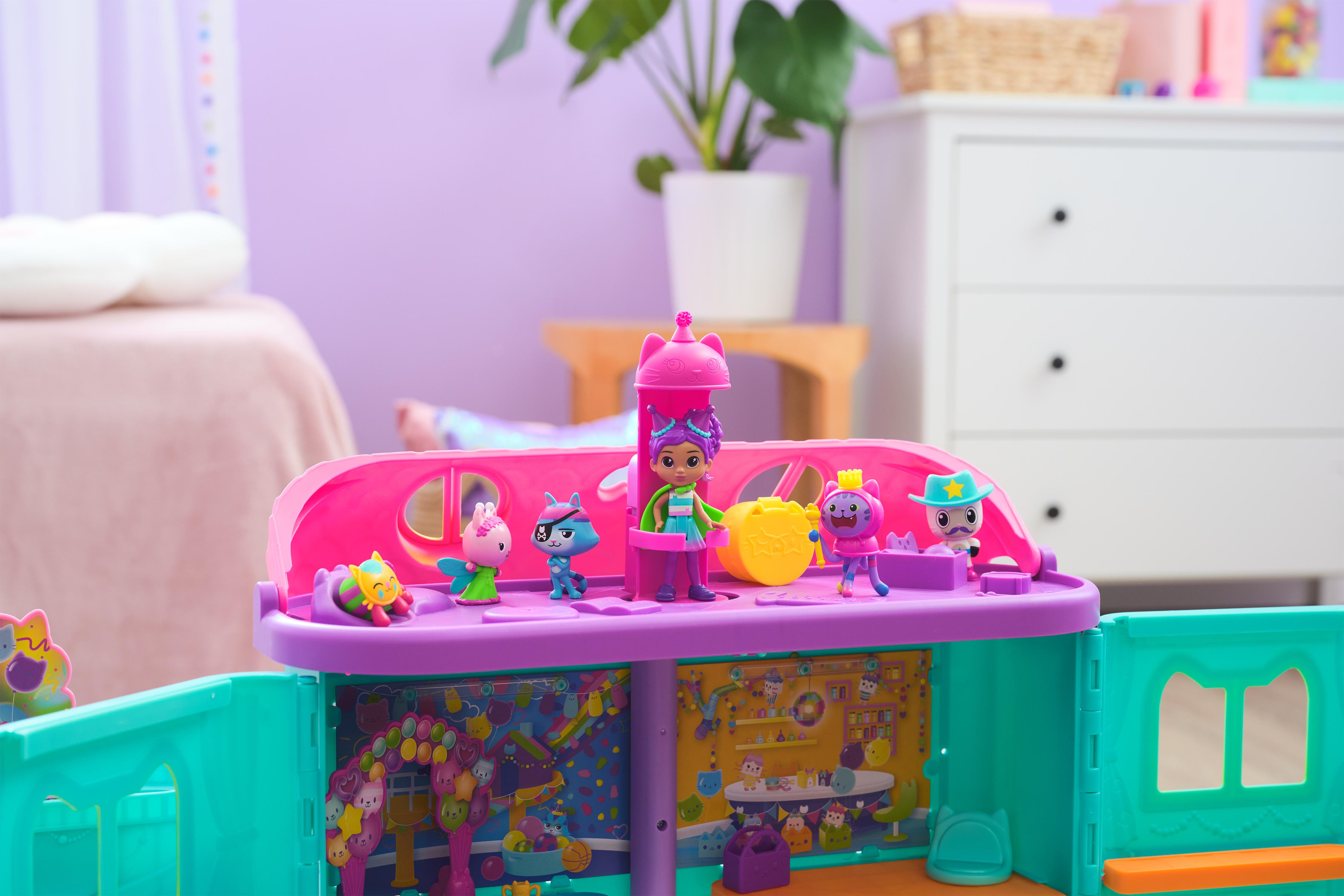 Zestaw zabawek z kolorowymi figurkami. Tło obejmuje łóżko, komodę i roślinę.