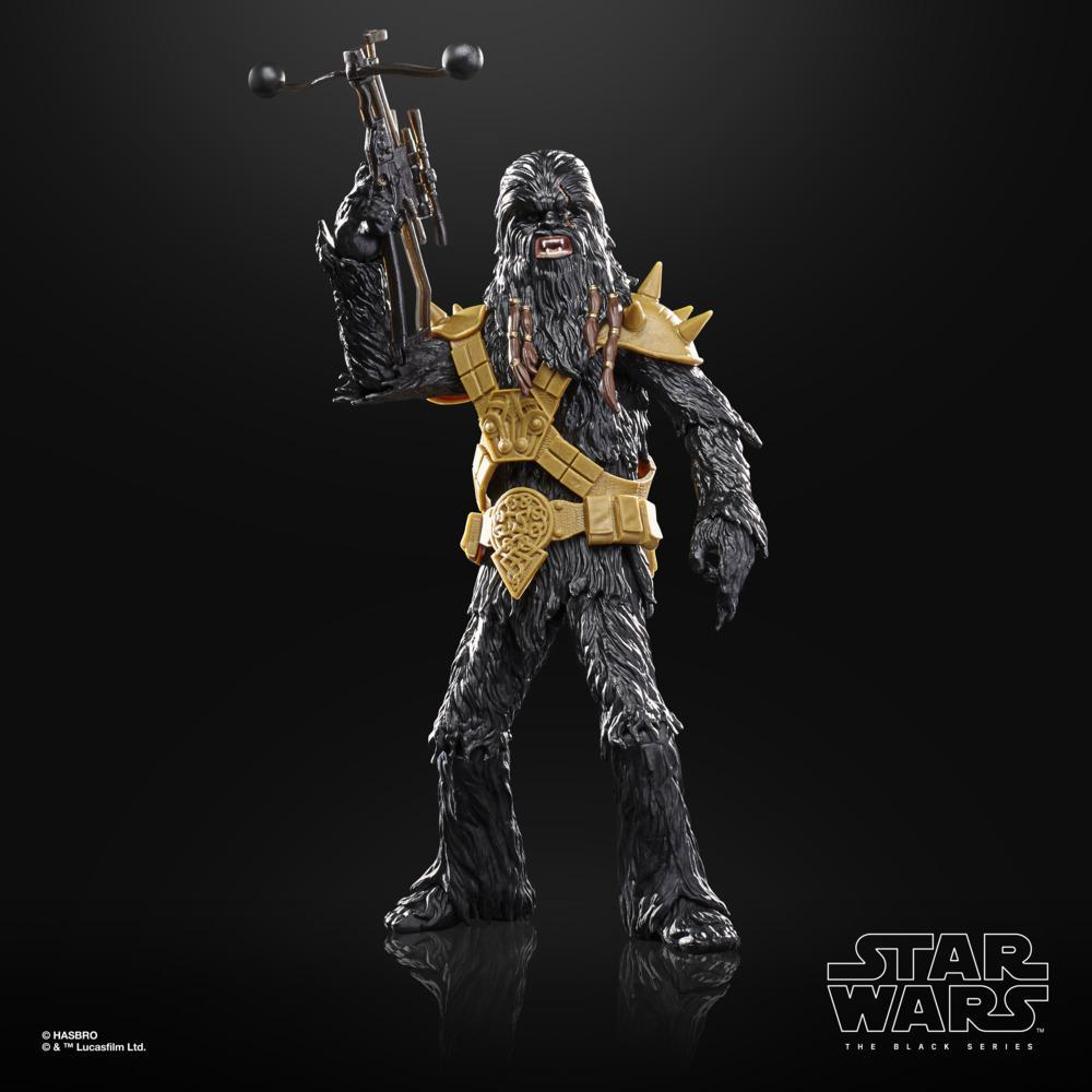 Action figure di Chewbacca in abito oro e nero, con una balestra. Logo di Star Wars in basso a destra.