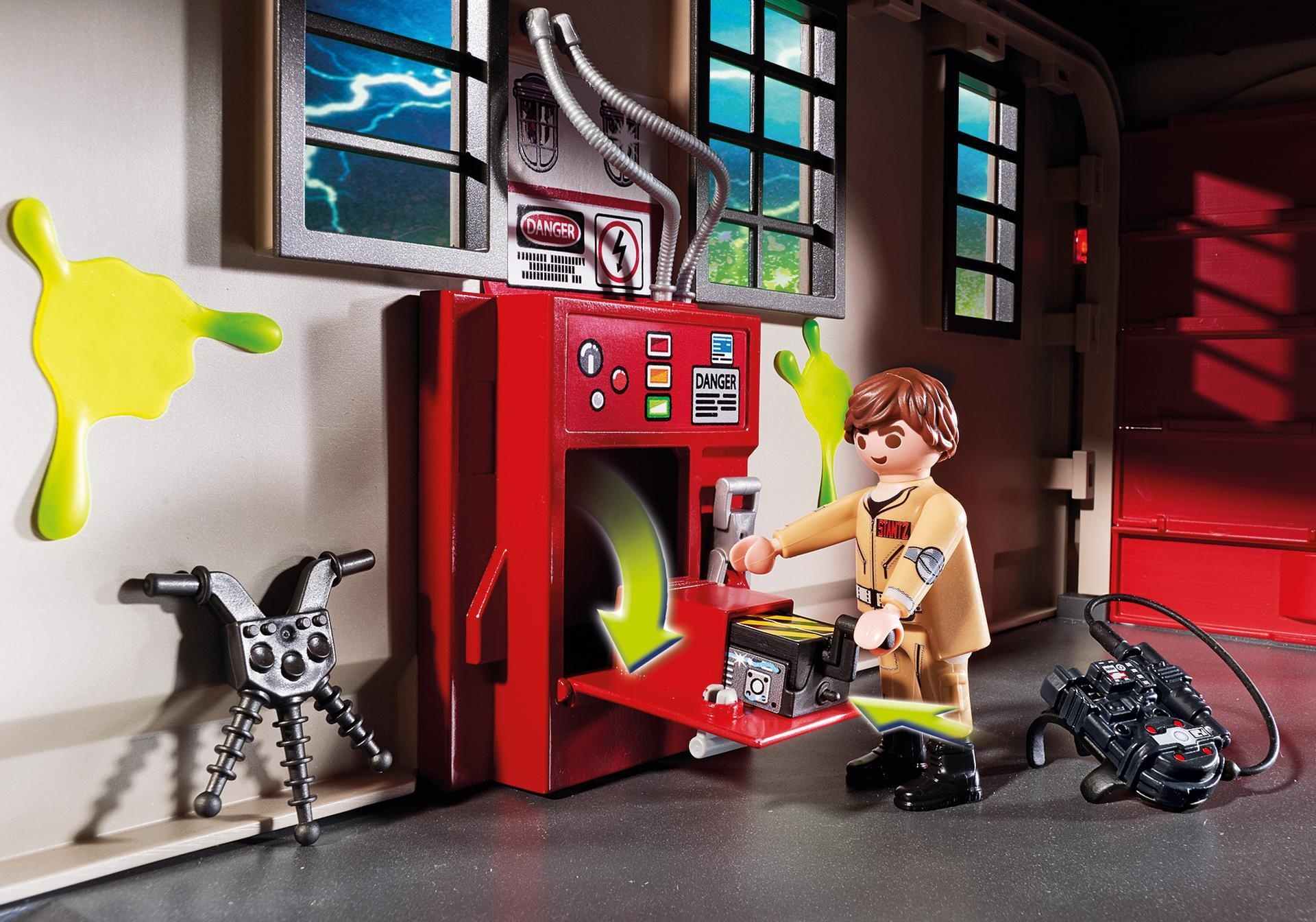 Eine Ghostbusters-Szene mit einer Figur, einer Maschine und Schleim. Die Figur hält ein Gerät. Im Hintergrund sind Fenster und eine rote Tür.