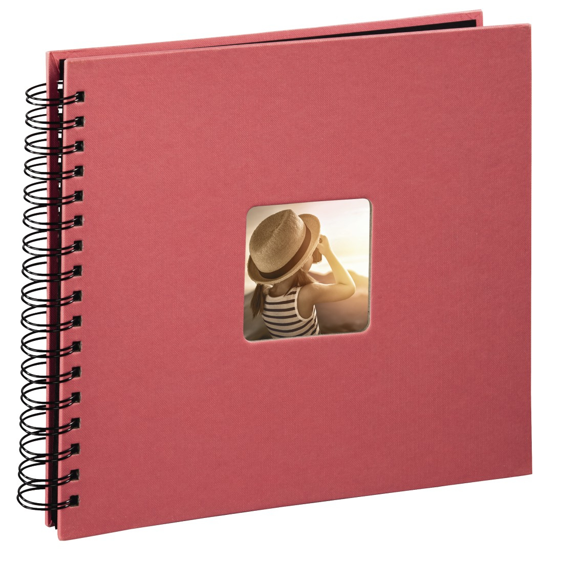 Czerwony album ze zdjęciami z małym zdjęciem osoby w kapeluszu, patrzącej na zachód słońca.
