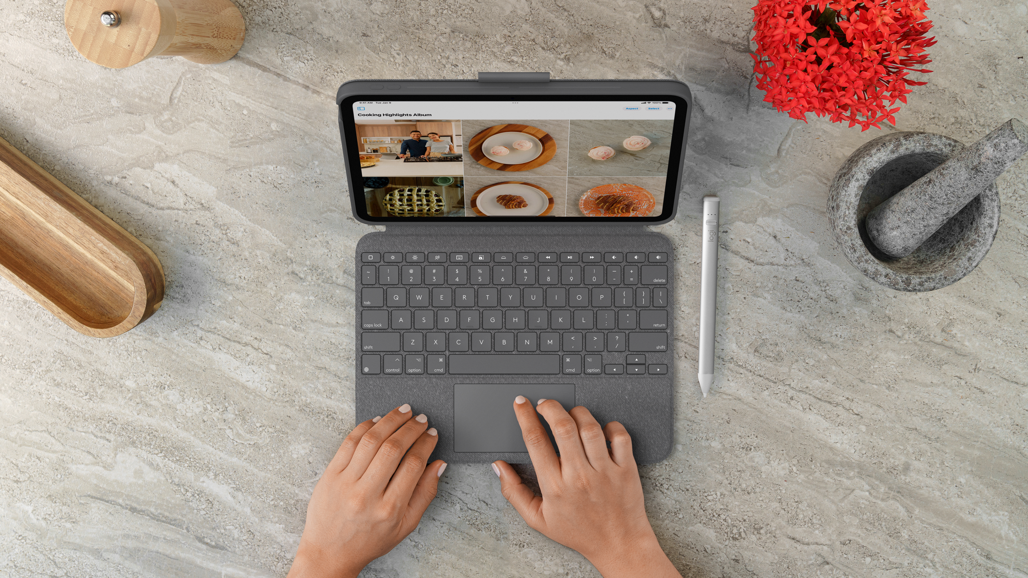 Vista dall'alto di tablet con tastiera, stilo e ricette in evidenza sullo schermo, su superficie marmorea.