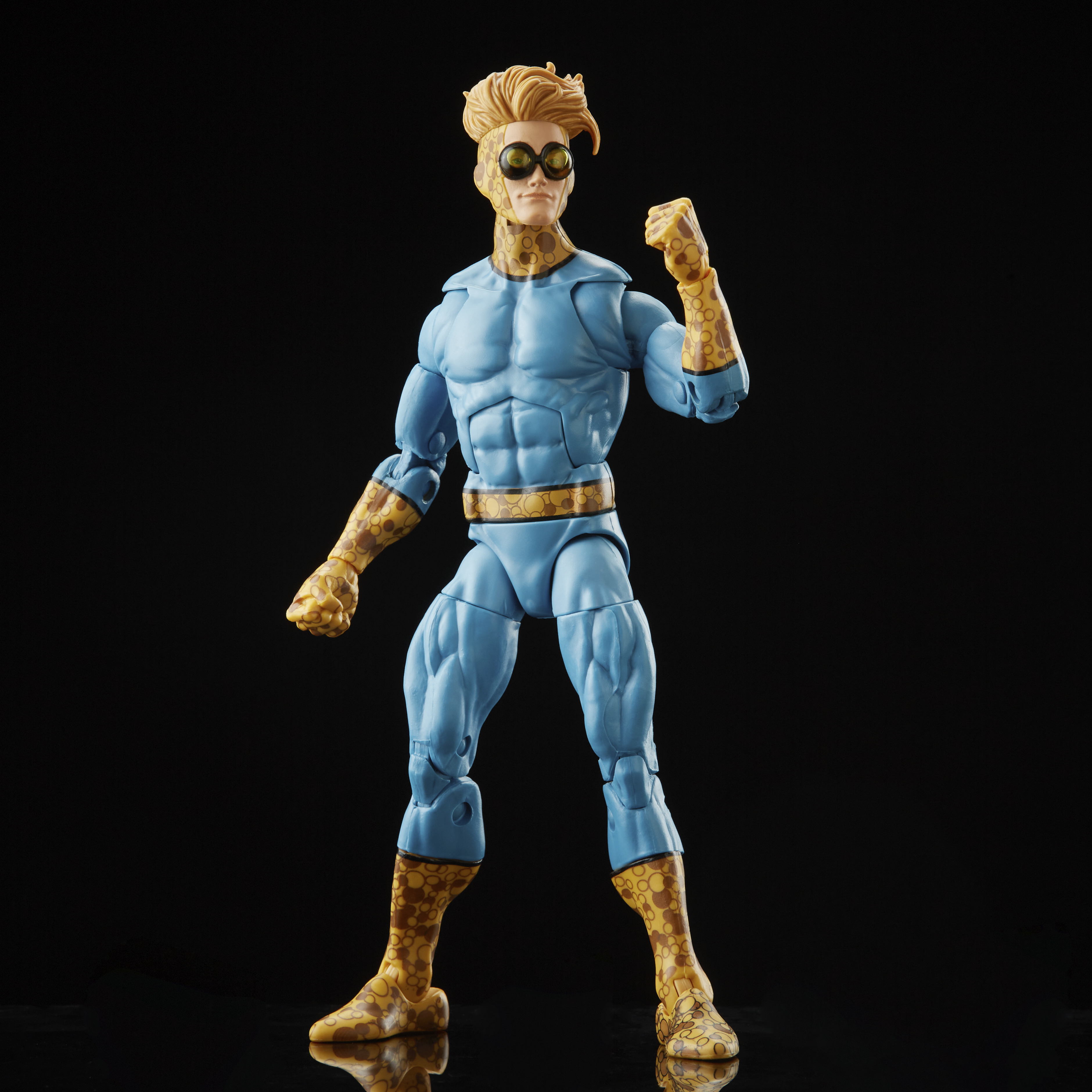 Una figura de acción de superhéroe con traje azul y amarillo, con gafas. Está contra un fondo negro.