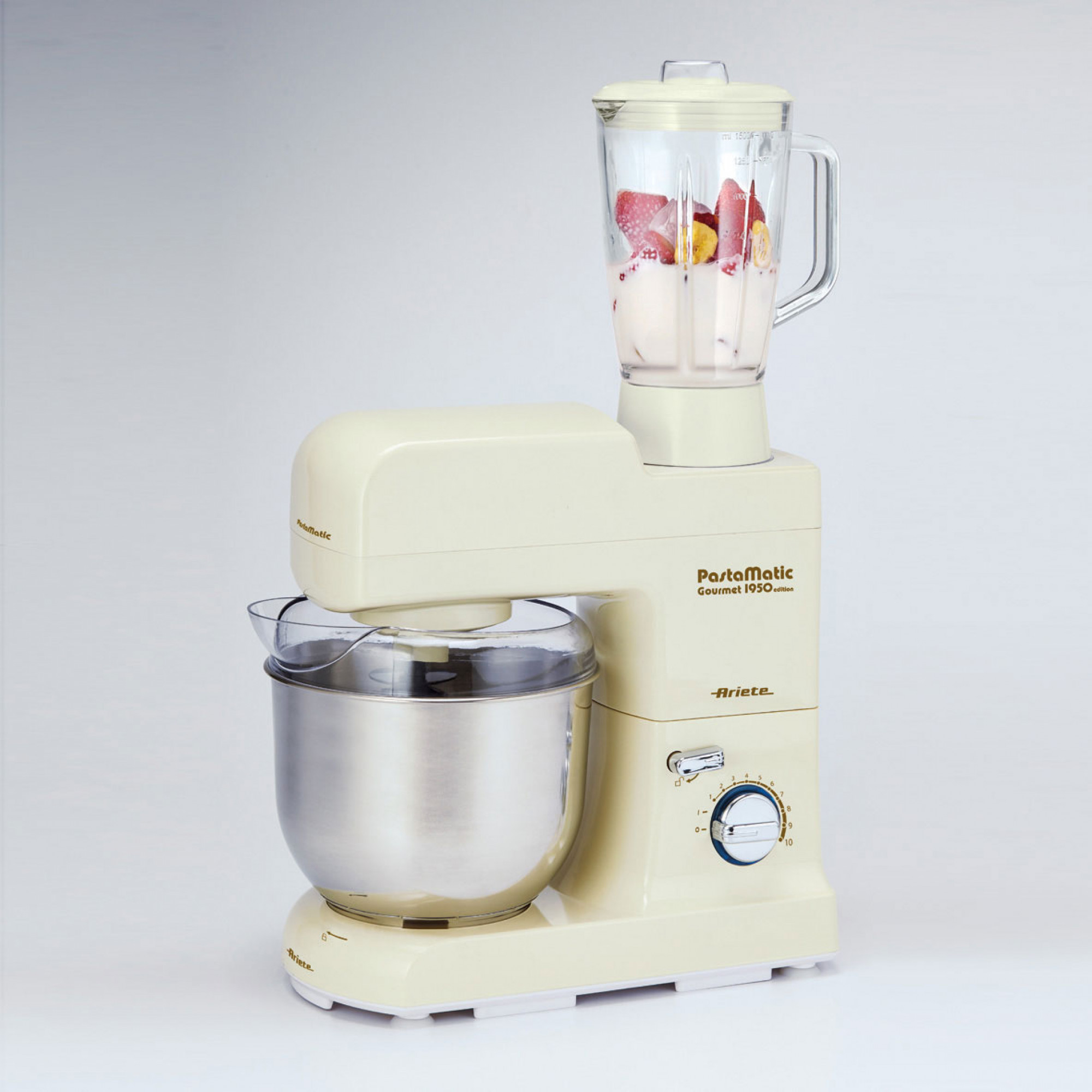 Procesador de alimentos color crema con una licuadora llena de fruta. Se ven un cuenco y un dial de control.