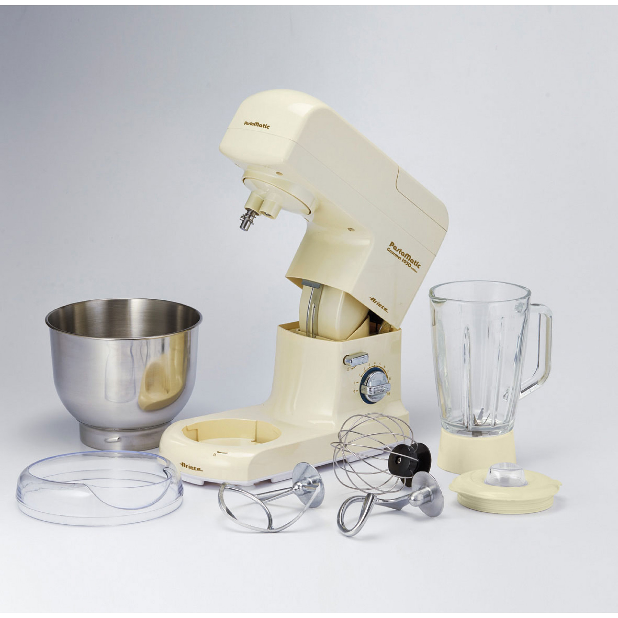 Una batidora Ariete PastaMatic crema con accesorios: cuenco, batidora, batidores. Piezas extendidas sobre superficie blanca.