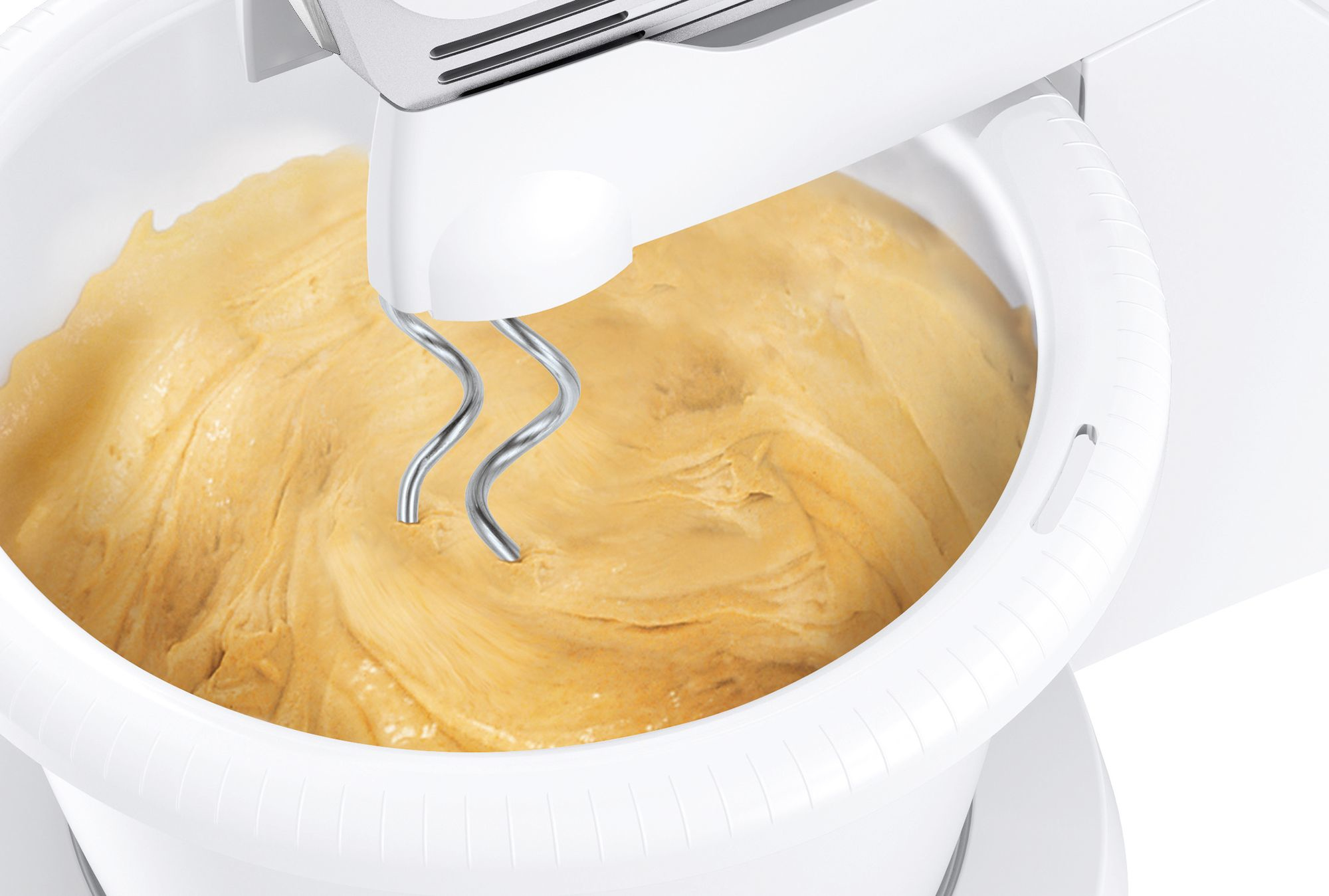 Ein weißer Mixer mit Teig in der Schüssel. Der Teig ist hellbraun. Die Rührbesen des Mixers sind silberfarben.