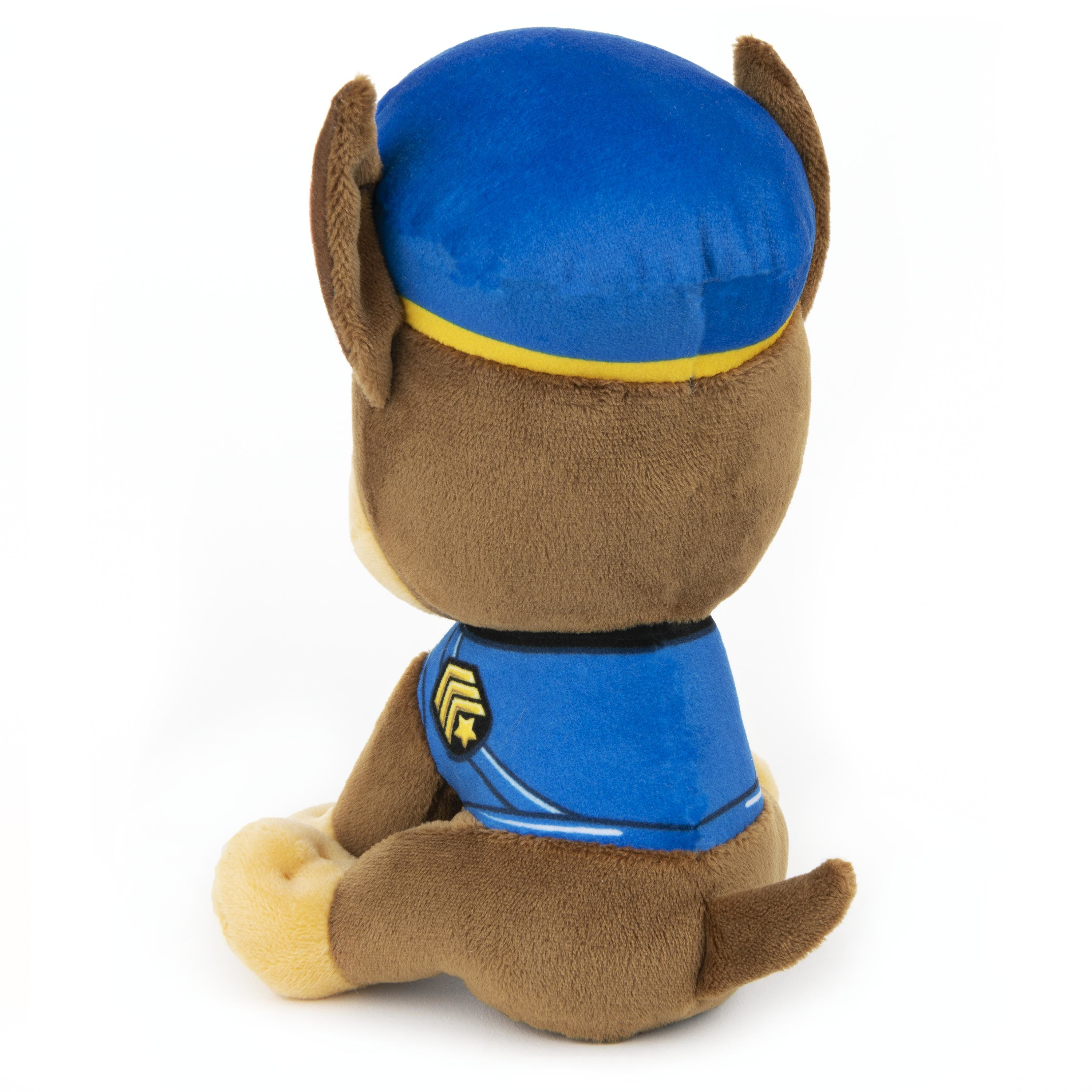 Ein Stofftier von Chase von Paw Patrol. Er ist braun und blau, sitzt, mit blauem Hut und Uniform.