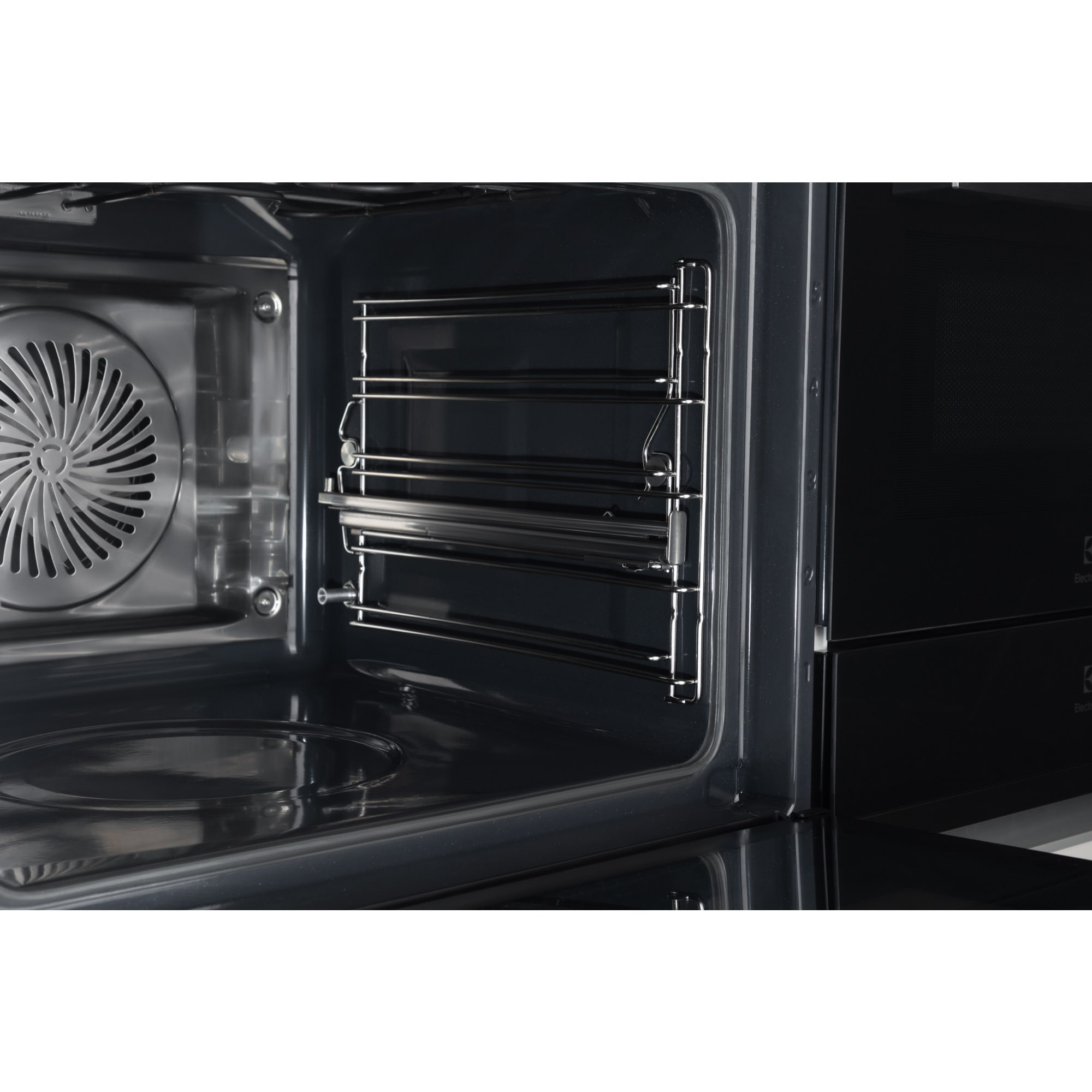 Vista interior de un horno. Tiene rejillas y un ventilador. La puerta del horno está abierta y hay un panel de control a la derecha.