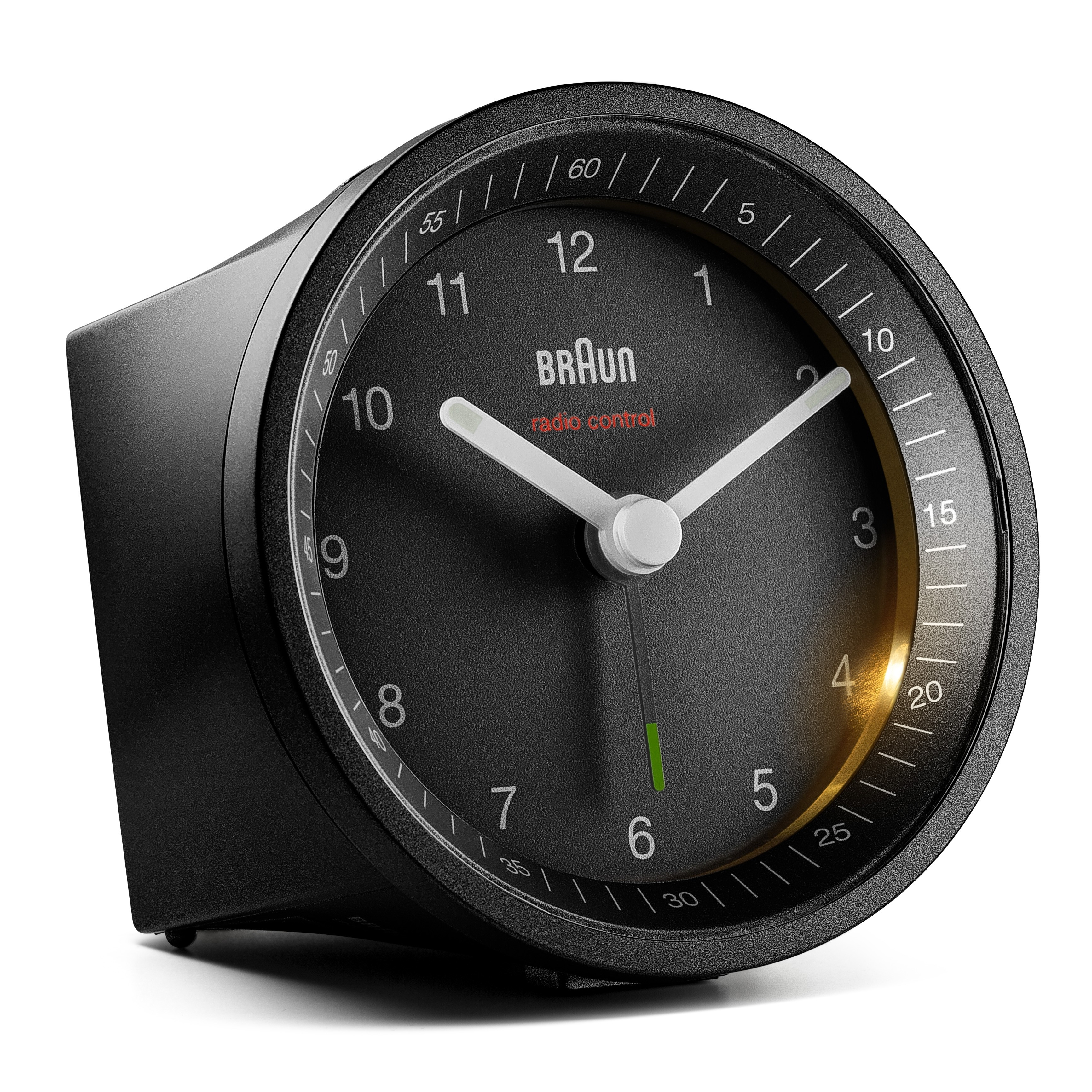 Un réveil Braun noir radiocommandé. Il a un cadran noir avec des aiguilles et des chiffres blancs. L'horloge est sur fond blanc.