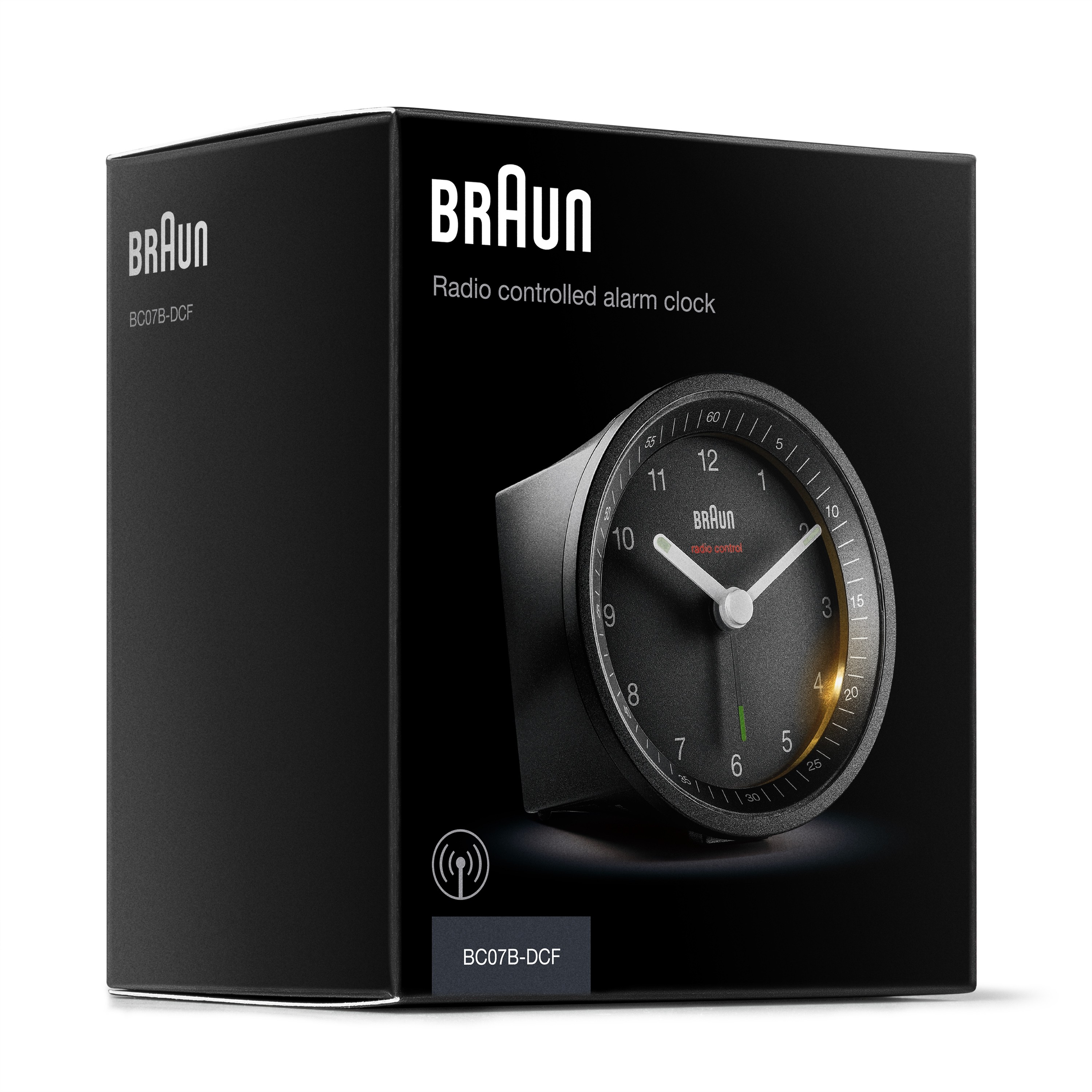 Réveil radio Braun noir dans une boîte noire. Le cadran est visible.