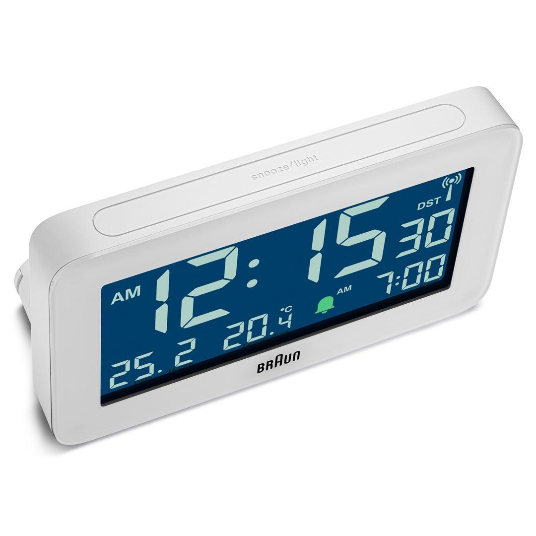 Weißer digitaler Braun-Wecker. Zeigt Zeit, Datum und Temperatur an. Hat Schlummer-/Lichtfunktion.
