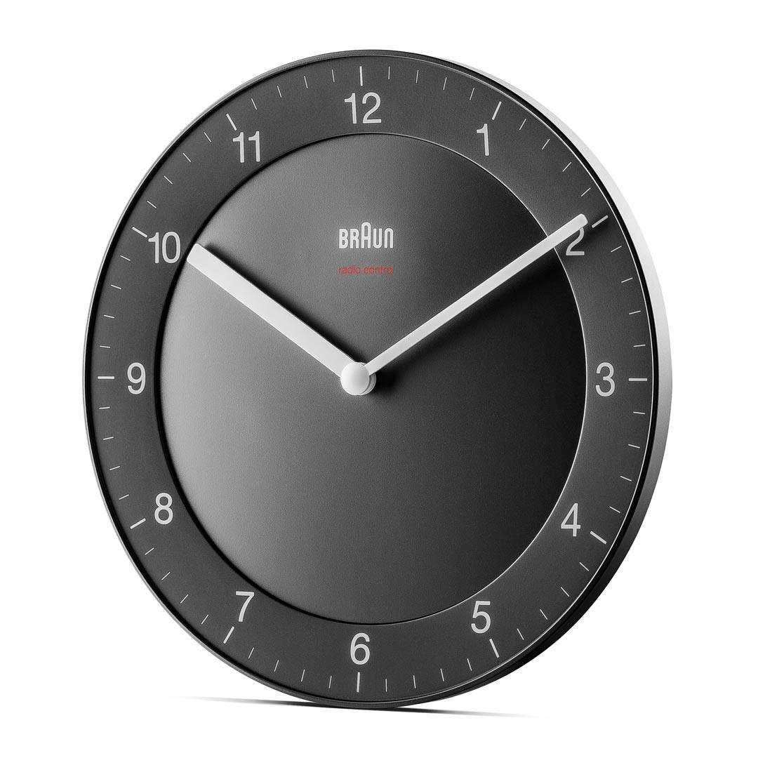 Eine schwarze Braun-Uhr mit weißen Zeigern, Zahlen und einem roten Schriftzug 'radio controlled'. Die Uhr ist rund.