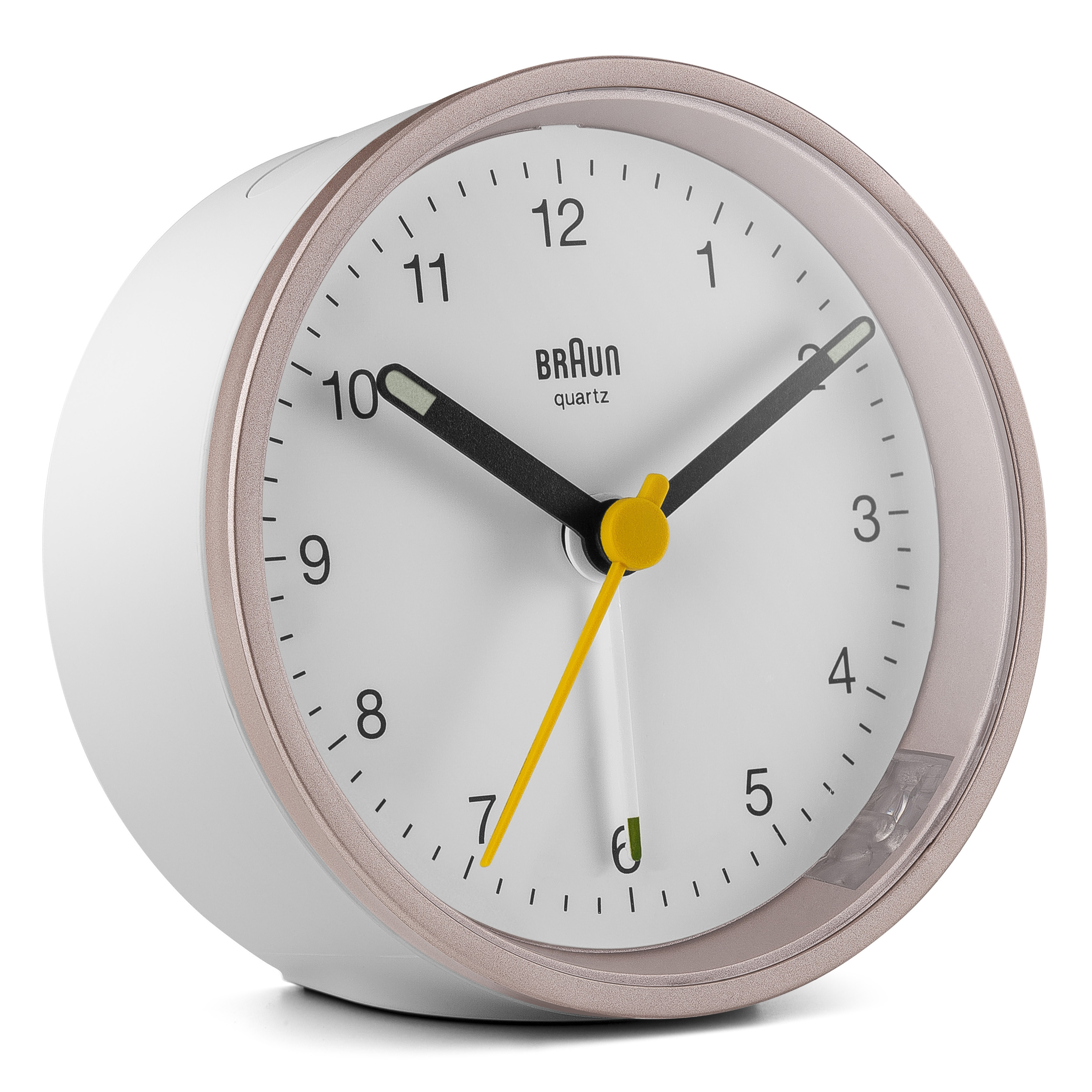 Un réveil Braun à quartz blanc et doré. Il a un cadran blanc, des aiguilles noires et une trotteuse jaune.