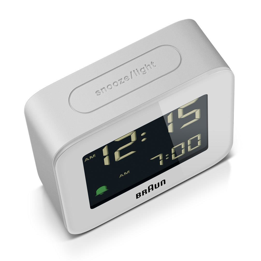 Ein weißer digitaler Braun-Wecker zeigt 12:15 Uhr an. Er hat eine Schlummer-/Licht-Taste und das Braun-Logo.