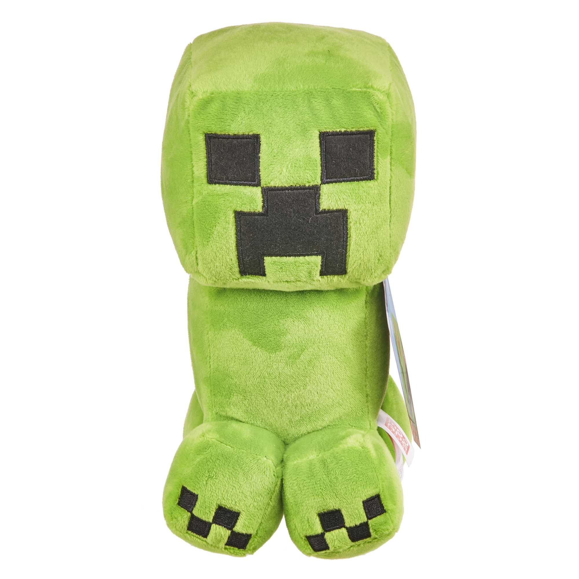 Ein grünes Minecraft Creeper Plüschtier. Es hat einen quadratischen Kopf, schwarze Augen und einen quadratischen Mund. Es sitzt.