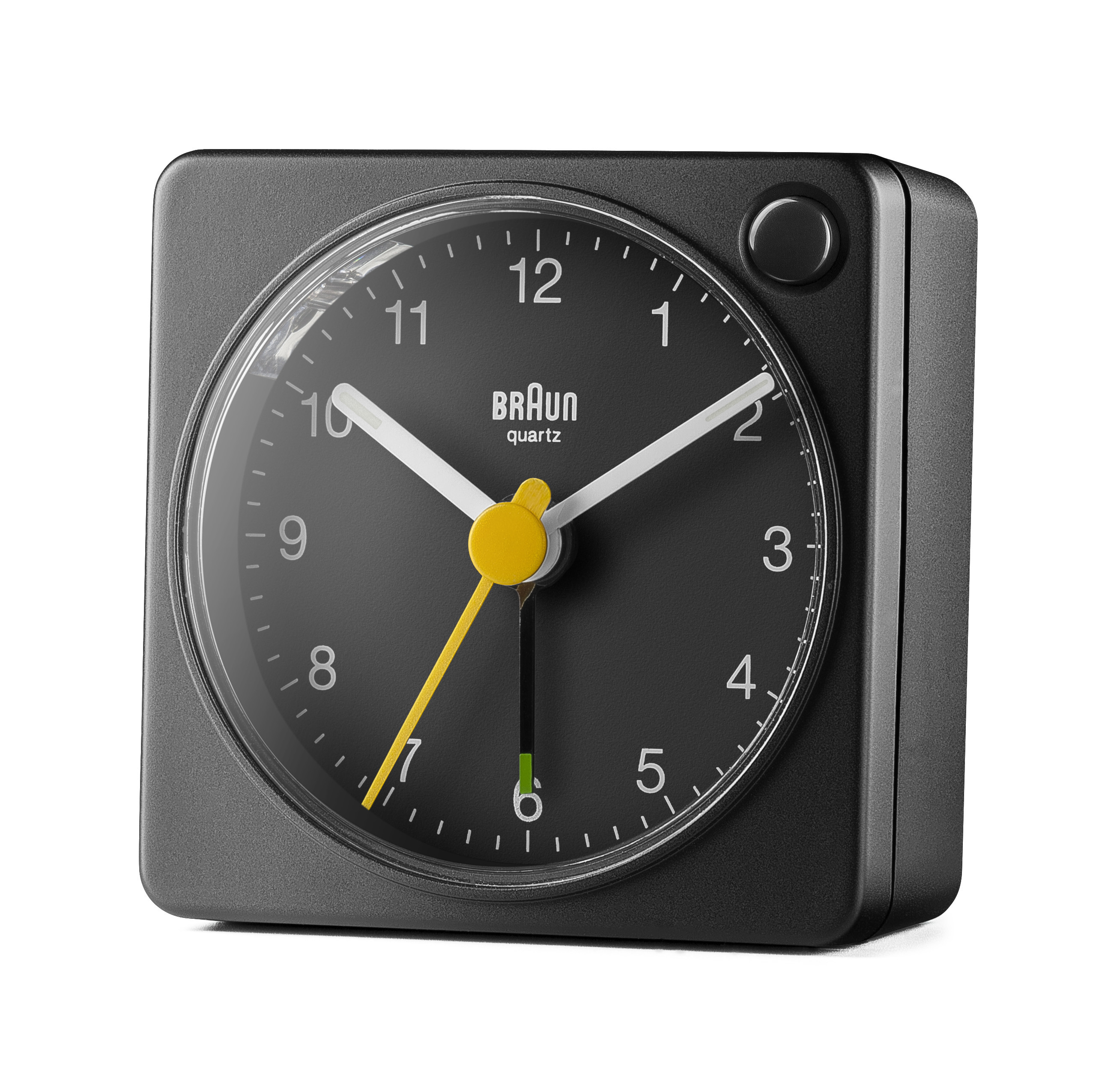 Ein quadratischer schwarzer Braun-Wecker mit schwarzem Zifferblatt und weißen und gelben Zeigern. Die Zeit ist ungefähr 1:30.
