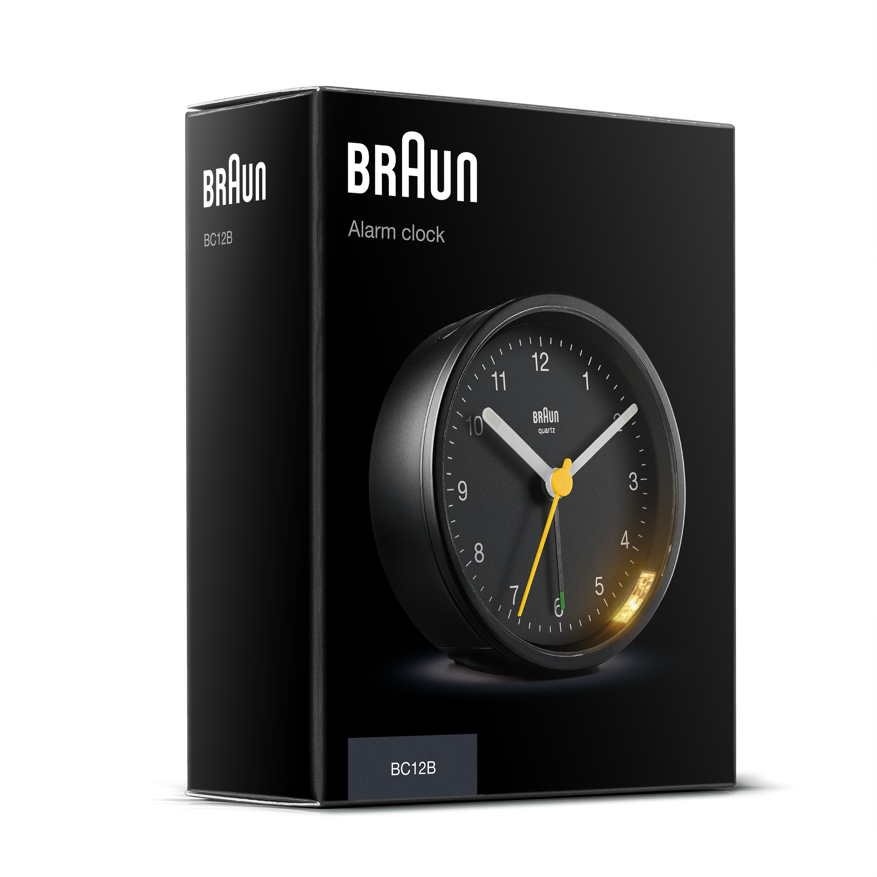 Una sveglia Braun nera nella sua scatola. L'orologio è rotondo con lancette bianche e una lancetta dei secondi gialla.
