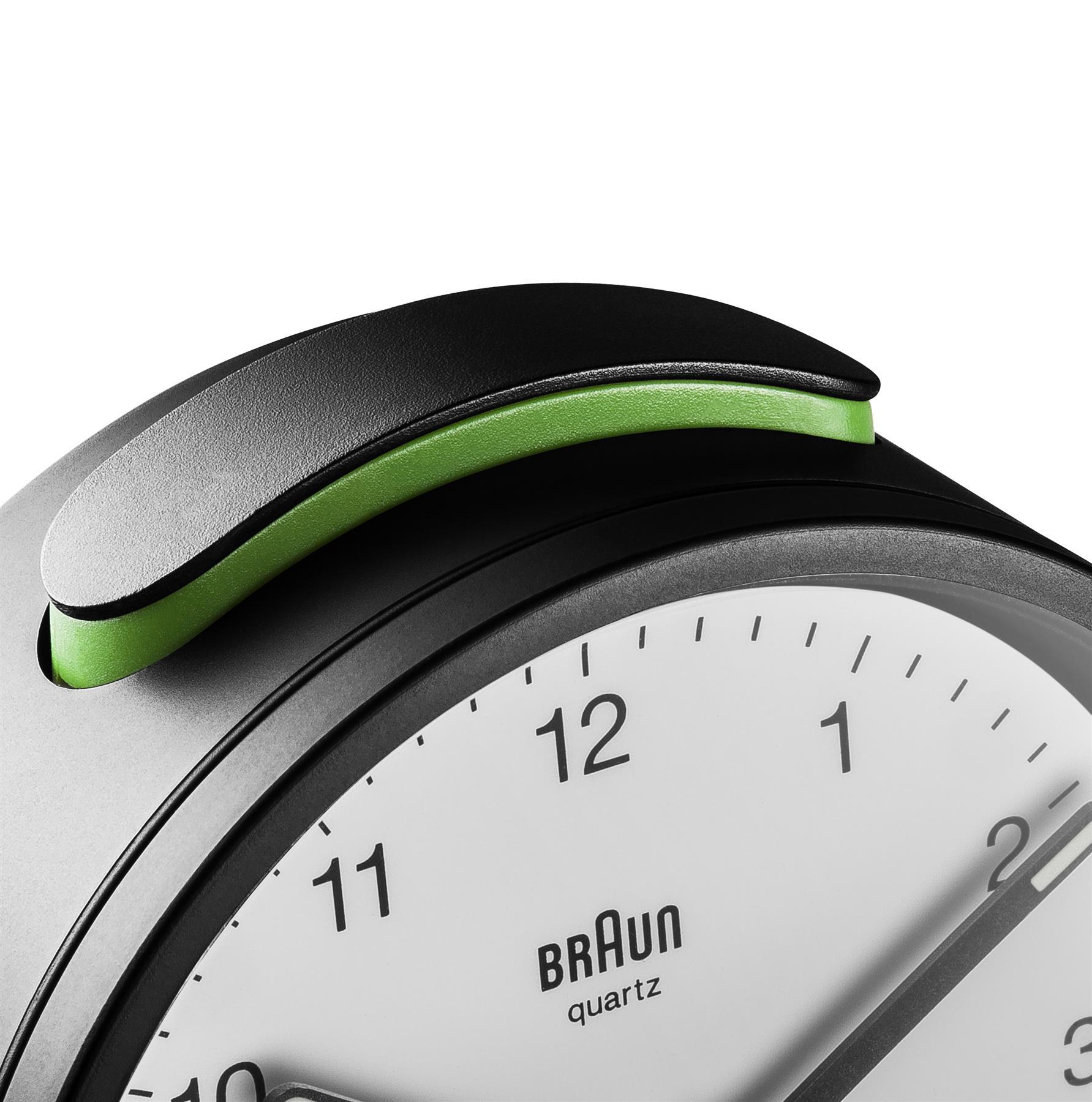 Gros plan sur un réveil à quartz Braun. Poignée noire et verte sur le dessus, cadran blanc avec chiffres noirs.
