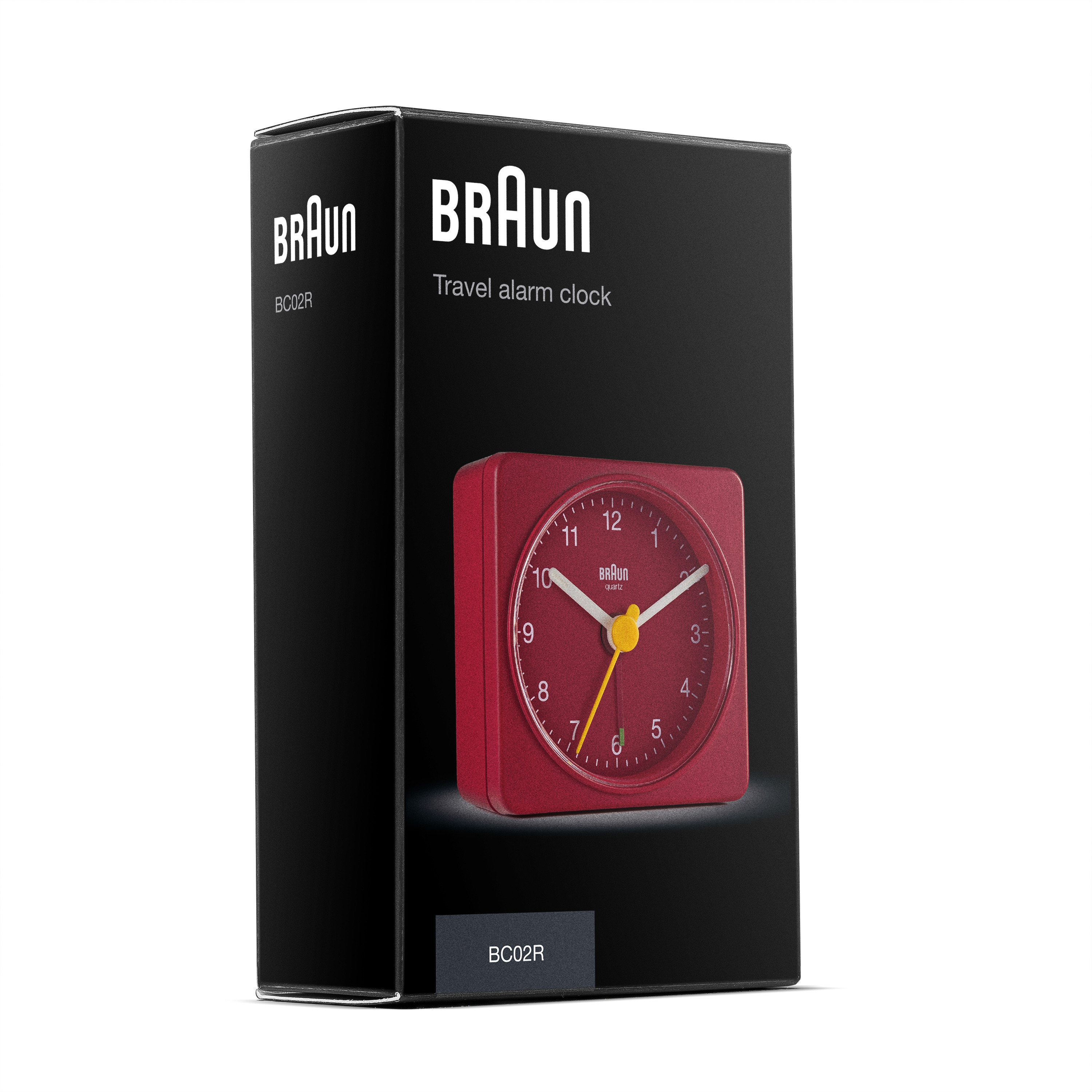 Un réveil de voyage Braun rouge dans une boîte noire. L'horloge a des aiguilles blanches et une trotteuse jaune.