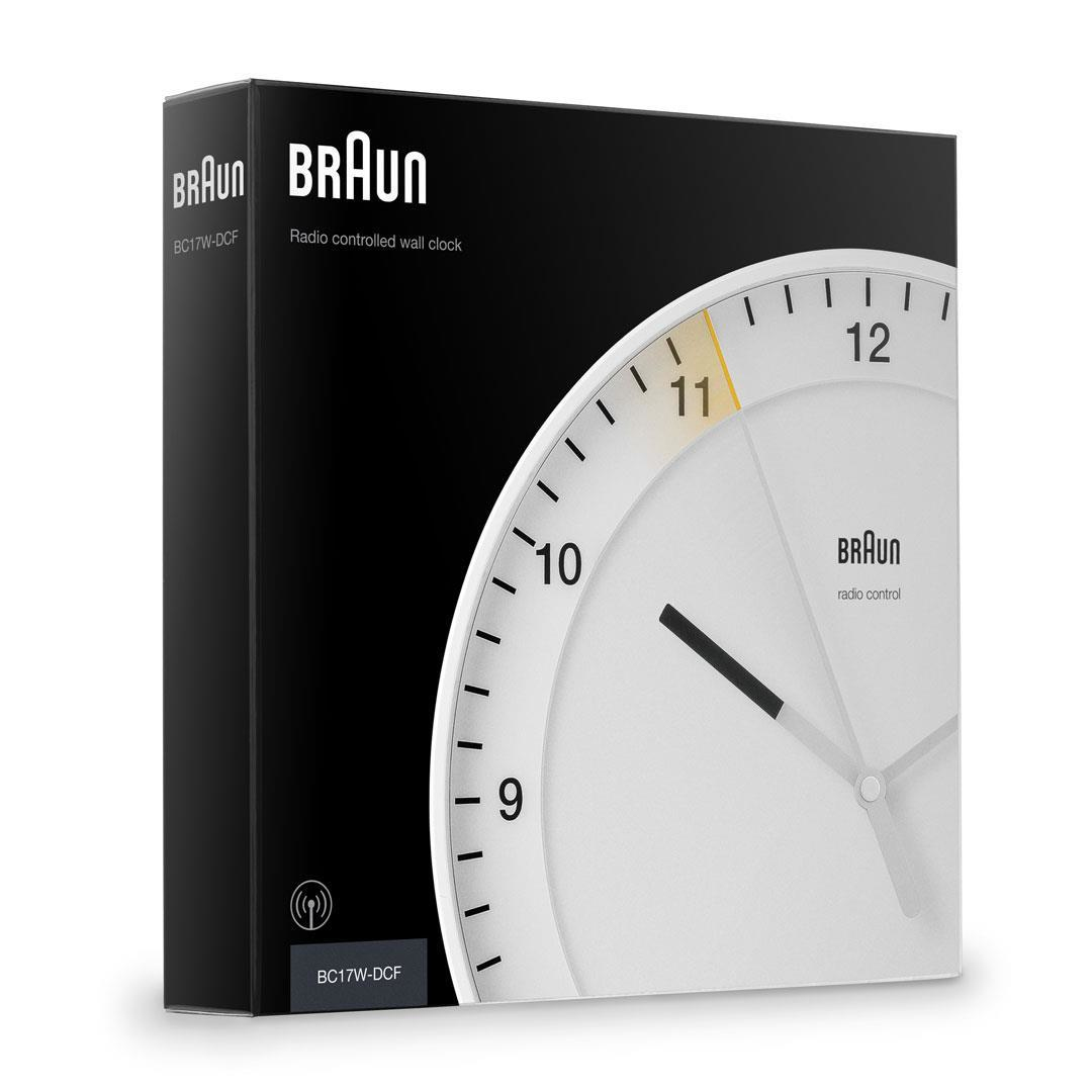 Eine funkgesteuerte Wanduhr von Braun wird angezeigt. Das weiße Zifferblatt zeigt die Uhrzeit, mit dem Markennamen unten.