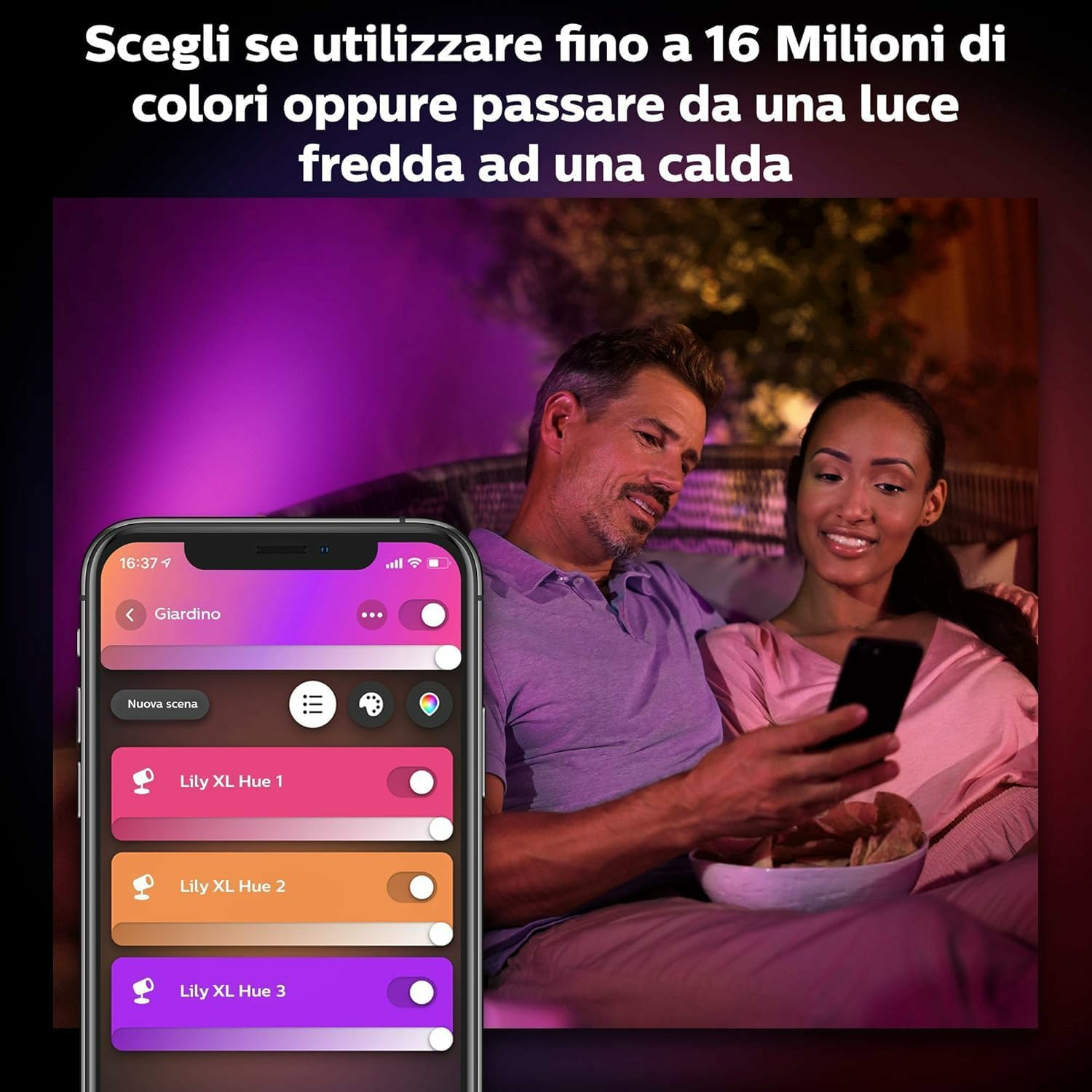 Ein Paar sitzt und schaut auf ein Telefon. Das Telefon zeigt eine Smart-Home-App zur Steuerung der Beleuchtung. Text auf Italienisch.