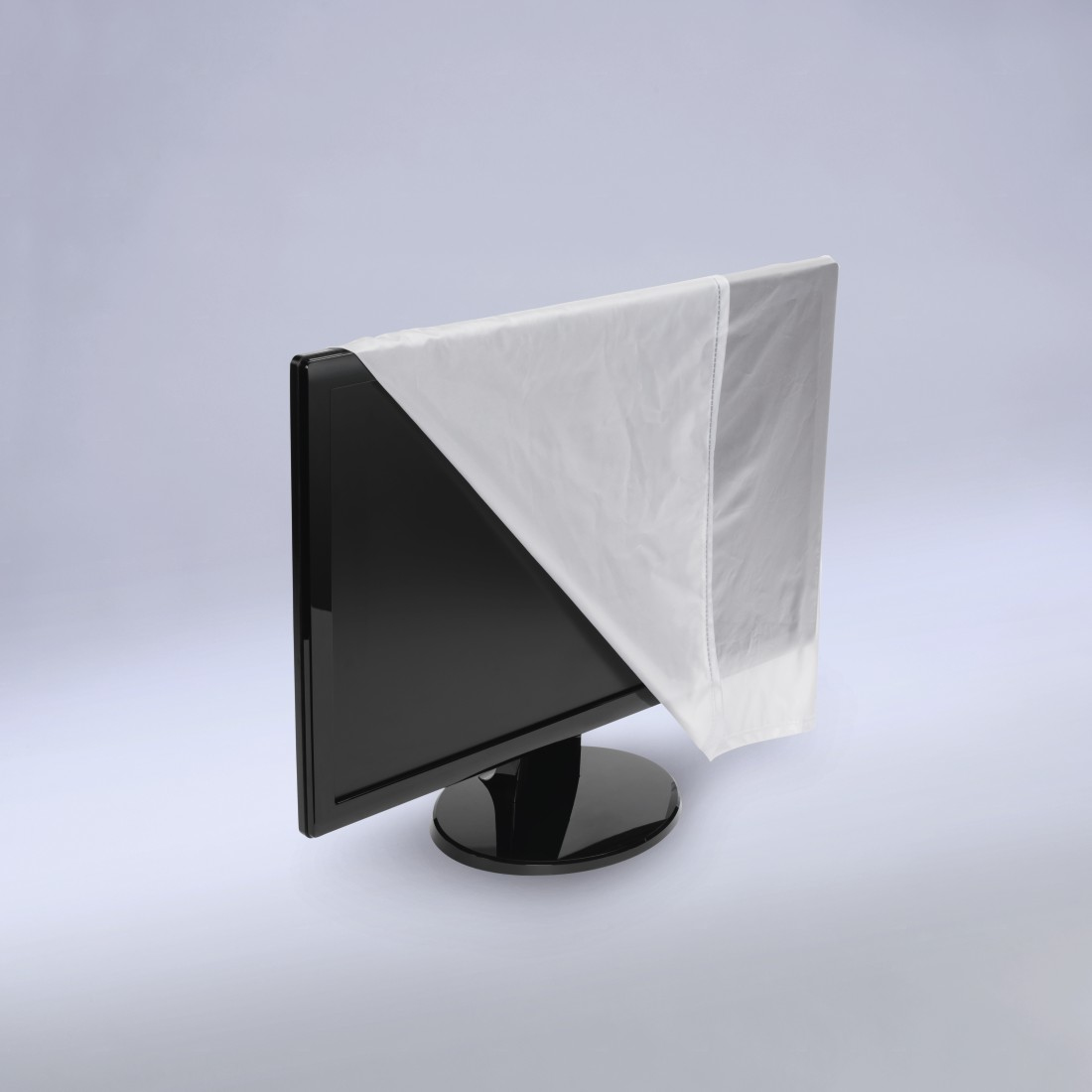 Ein schwarzer Computermonitor ist teilweise mit einem weißen Tuch bedeckt. Der Monitor steht auf einem schwarzen Ständer vor einem hellgrauen Hintergrund.