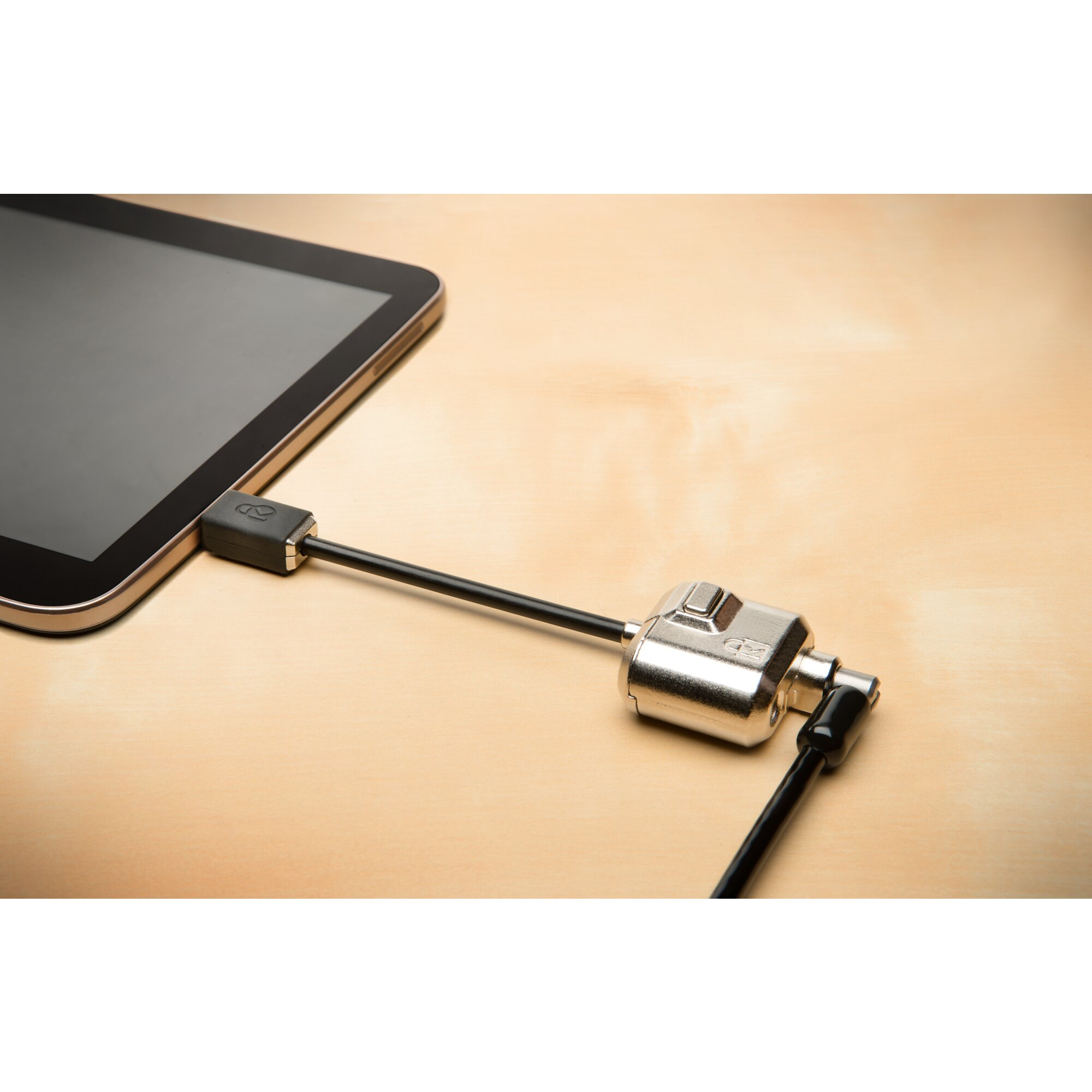 Tablet mit Schloss verbunden. Schwarzes Kabel und Schloss auf einem Holztisch. Tablet ist schwarz.