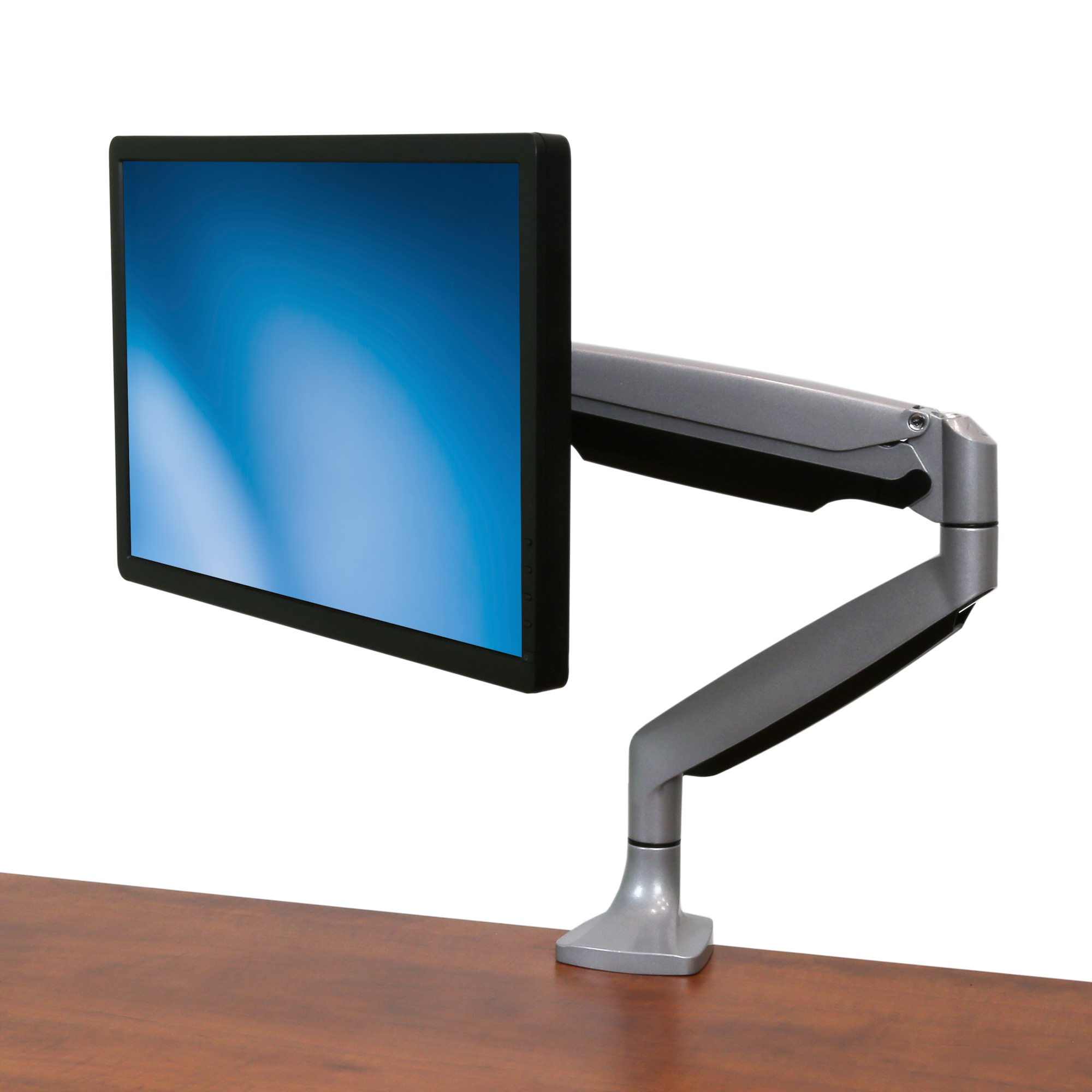 Ein Computermonitor ist auf einem grauen, verstellbaren Arm montiert, der auf einem braunen Holzschreibtisch steht, vor weißem Hintergrund.
