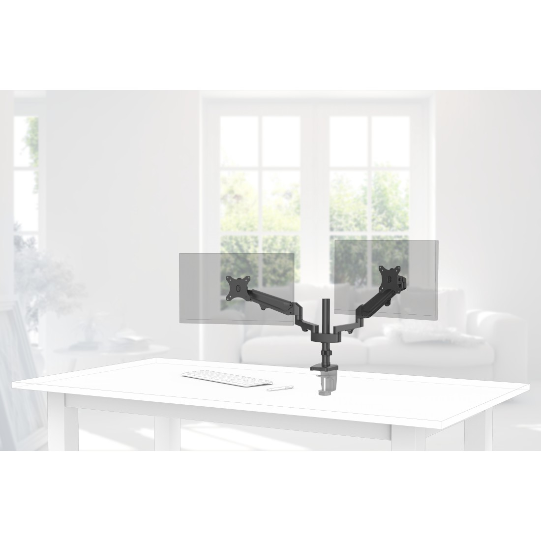 Uchwyt na dwa monitory na białym biurku. W tle jasny pokój z oknami i sofą.