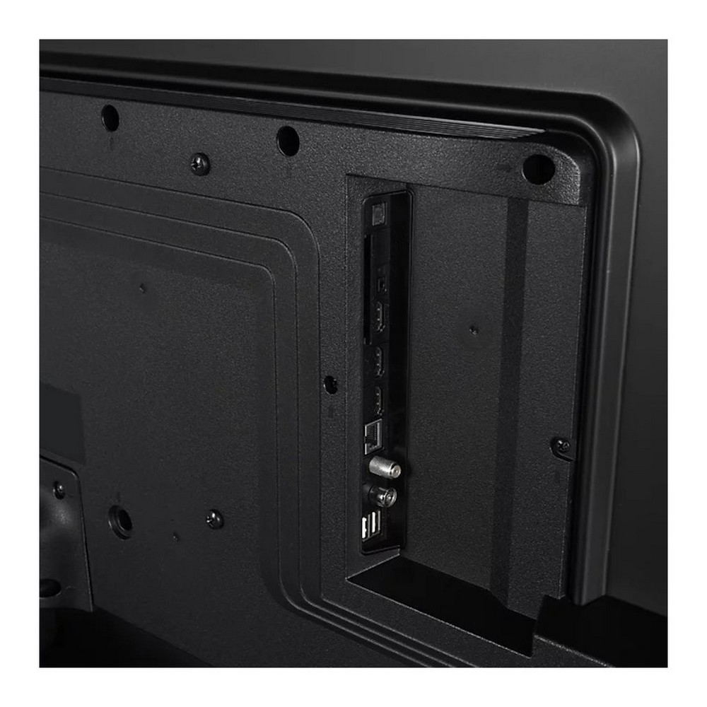 Vista trasera de un televisor negro. Visibles puertos HDMI, USB y antena. Superficie texturizada con orificios para tornillos.
