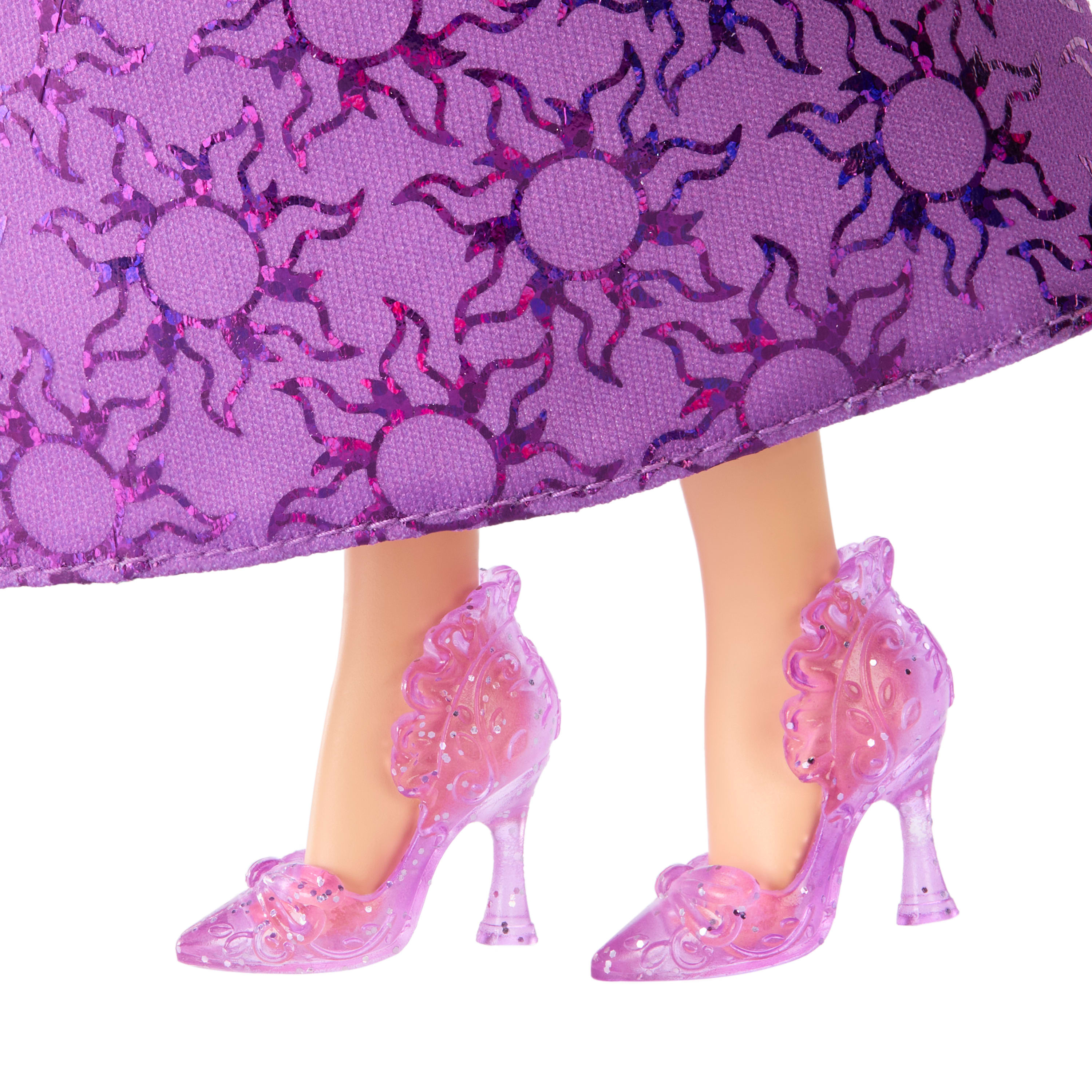 Nogi lalki w fioletowej sukience i pasujących szpilkach. Sukienka ma wzór słońca. Buty są przezroczyste.