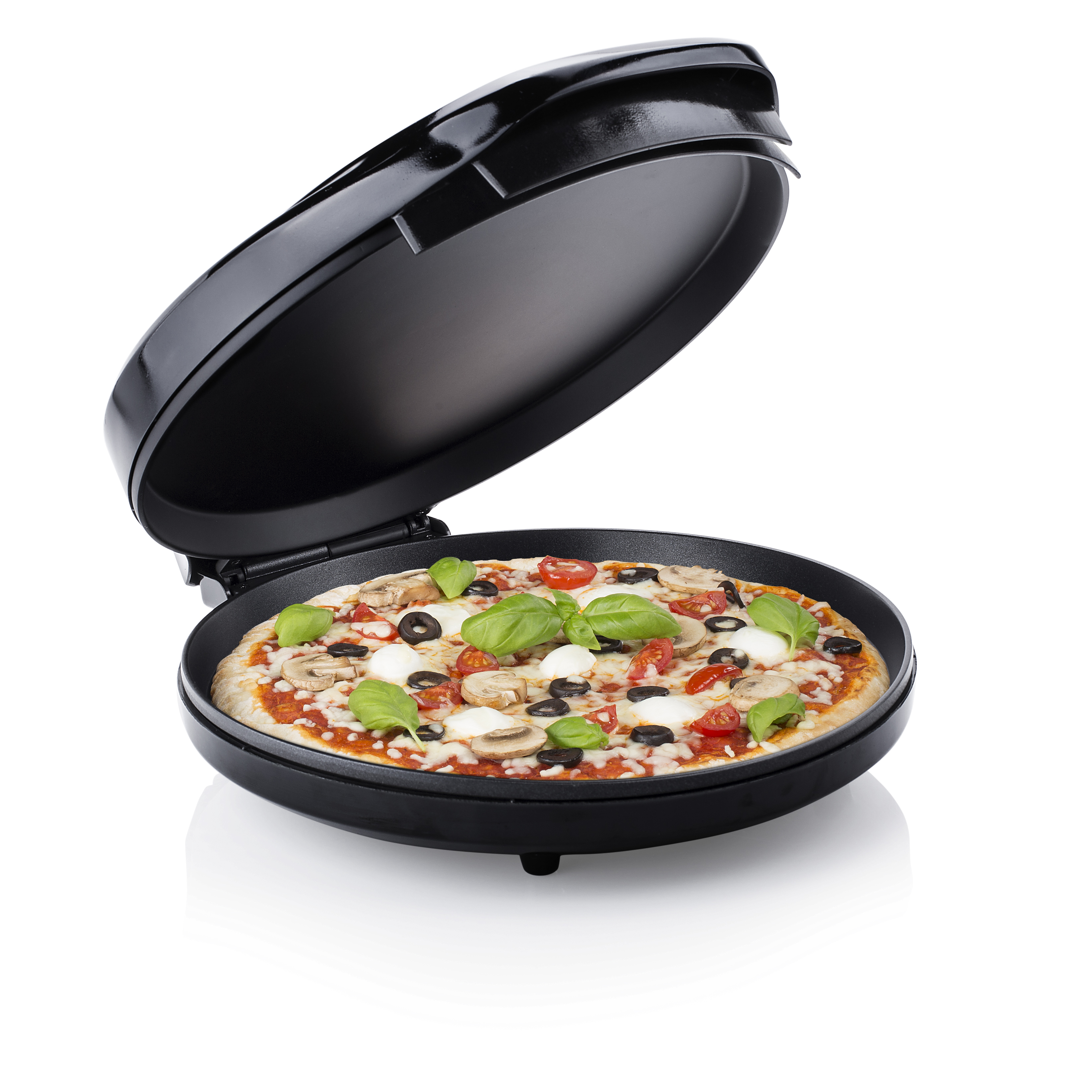 Pizza dans un appareil à pizza noir. Elle contient des tomates, des olives, des champignons et du basilic.