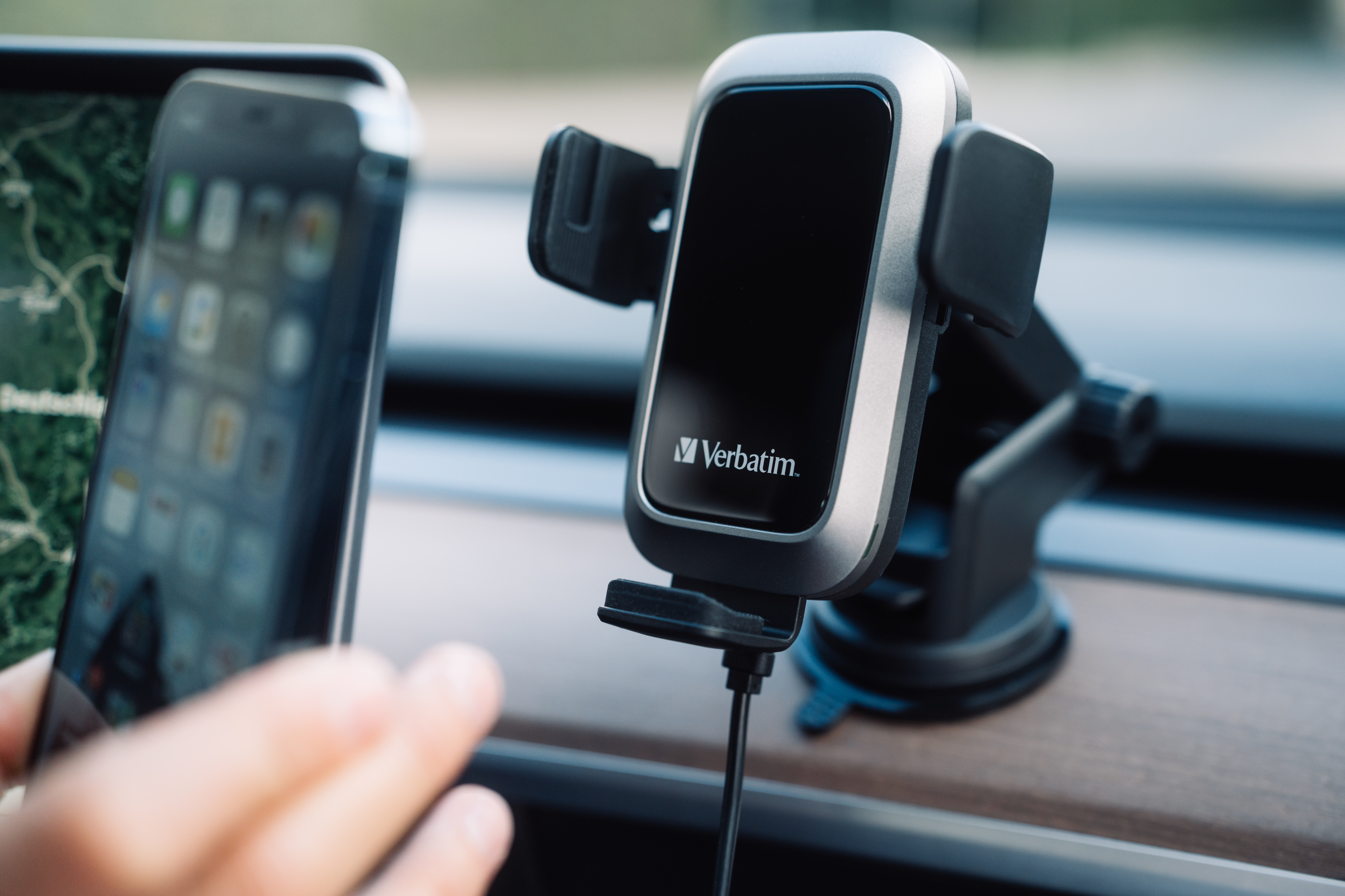 Interior de un coche con un teléfono en un soporte, otro teléfono a la izquierda, ambos borrosos. Enfoque en un soporte.
