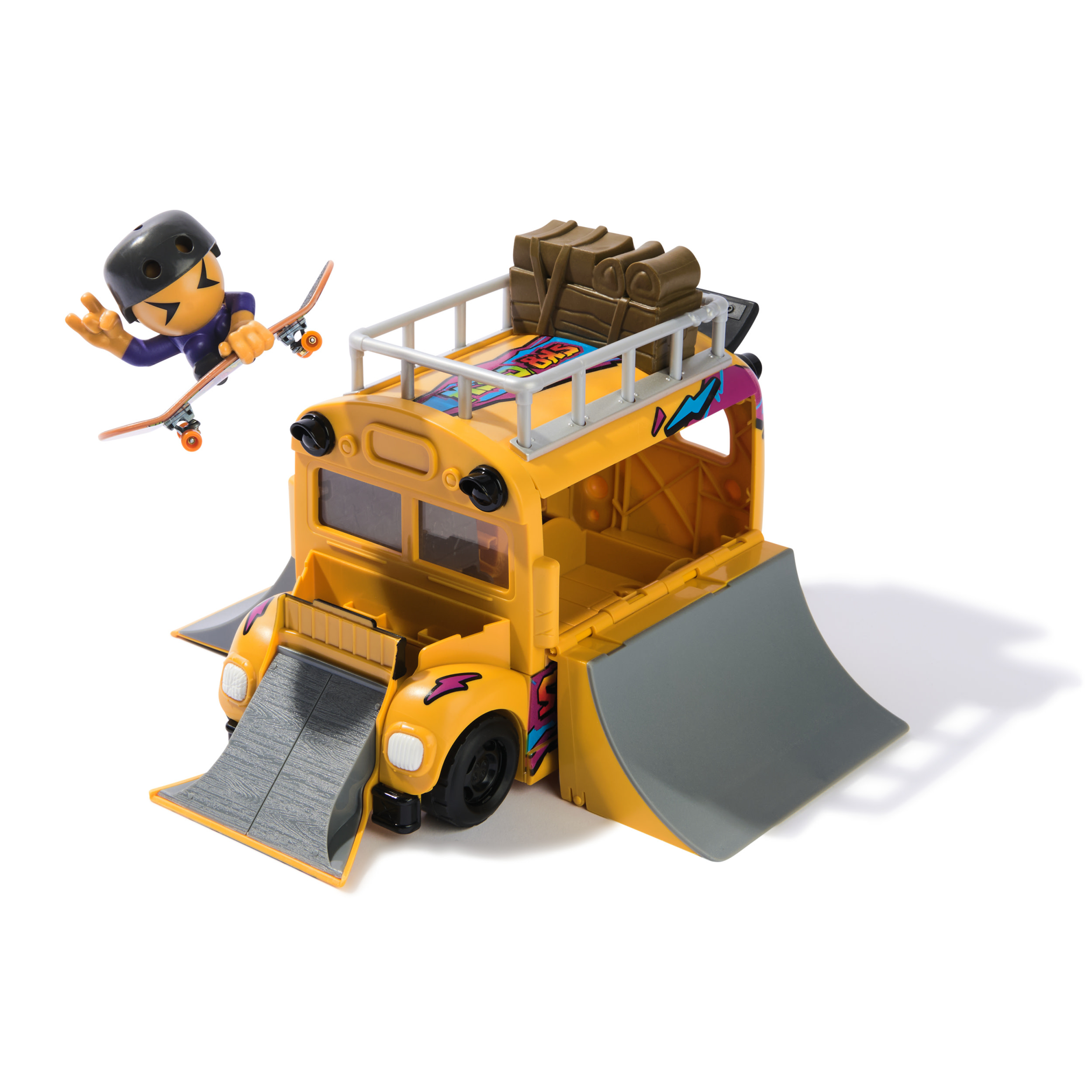 Ein gelber Spielzeug-Schulbus mit Rampen und einem Skateboarder. Der Bus hat Gepäck auf dem Dach. Vorne ist eine Rampe.