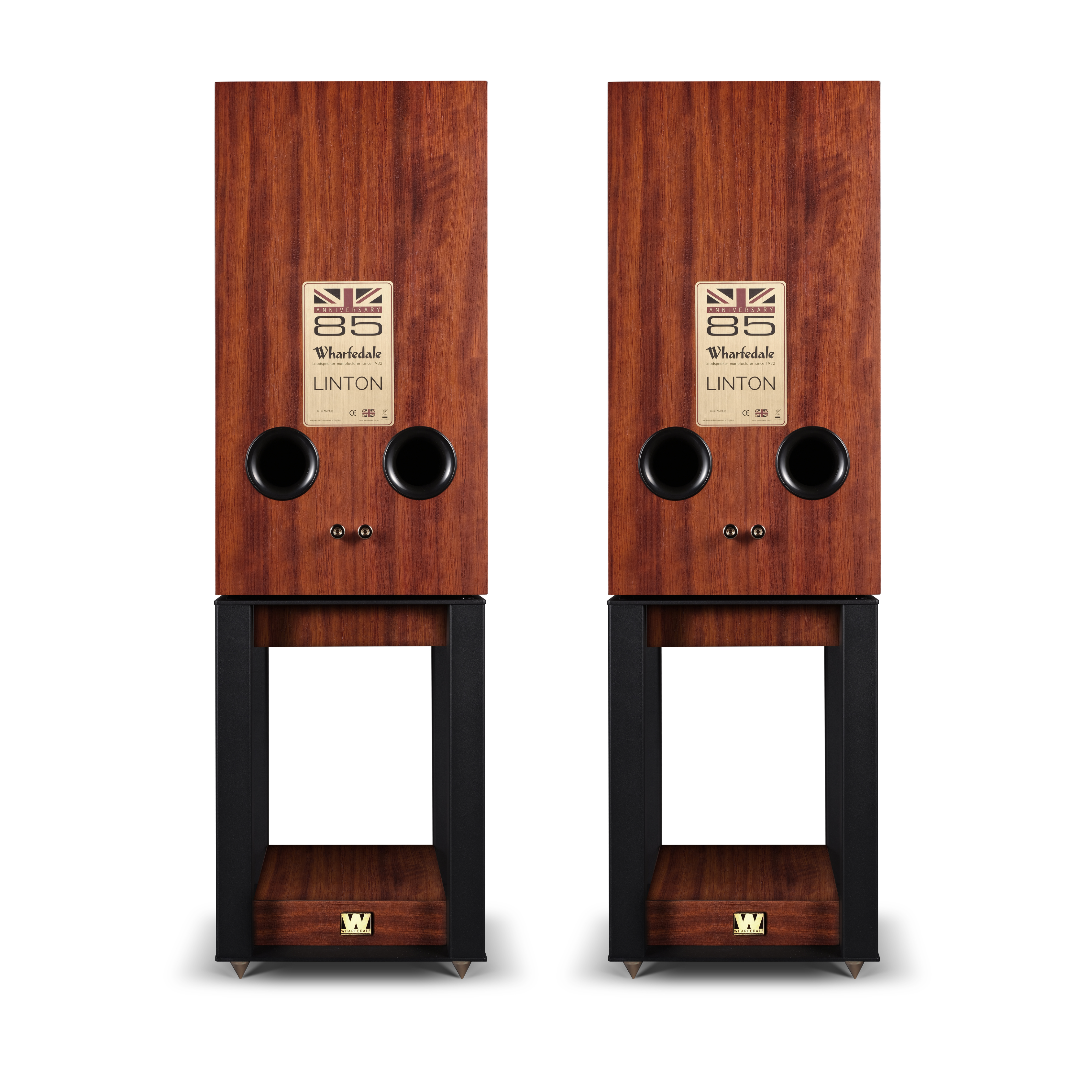 Twee houten luidsprekers met zwarte stands op een witte achtergrond. Elk heeft een logo en twee zwarte gaten.