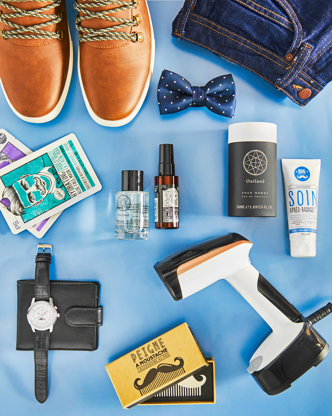 Accesorios para hombres sobre azul. Zapatos, pajarita, cuidado de la piel, reloj, cartera, aceite para barba, mascarilla facial, peine y vaporizador.