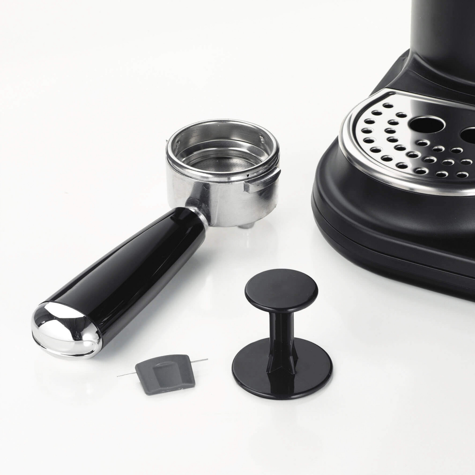 Części ekspresu do kawy na białym tle. Zawiera kolbę, ubijak i podstawę ekspresu.