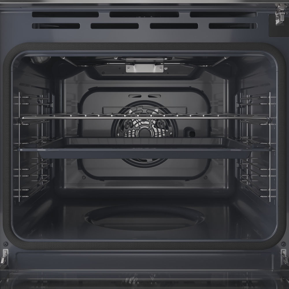 Vista interna di un forno nero. Ha griglie e una ventola. Un vassoio è sulla griglia inferiore. Lo sportello del forno è aperto.