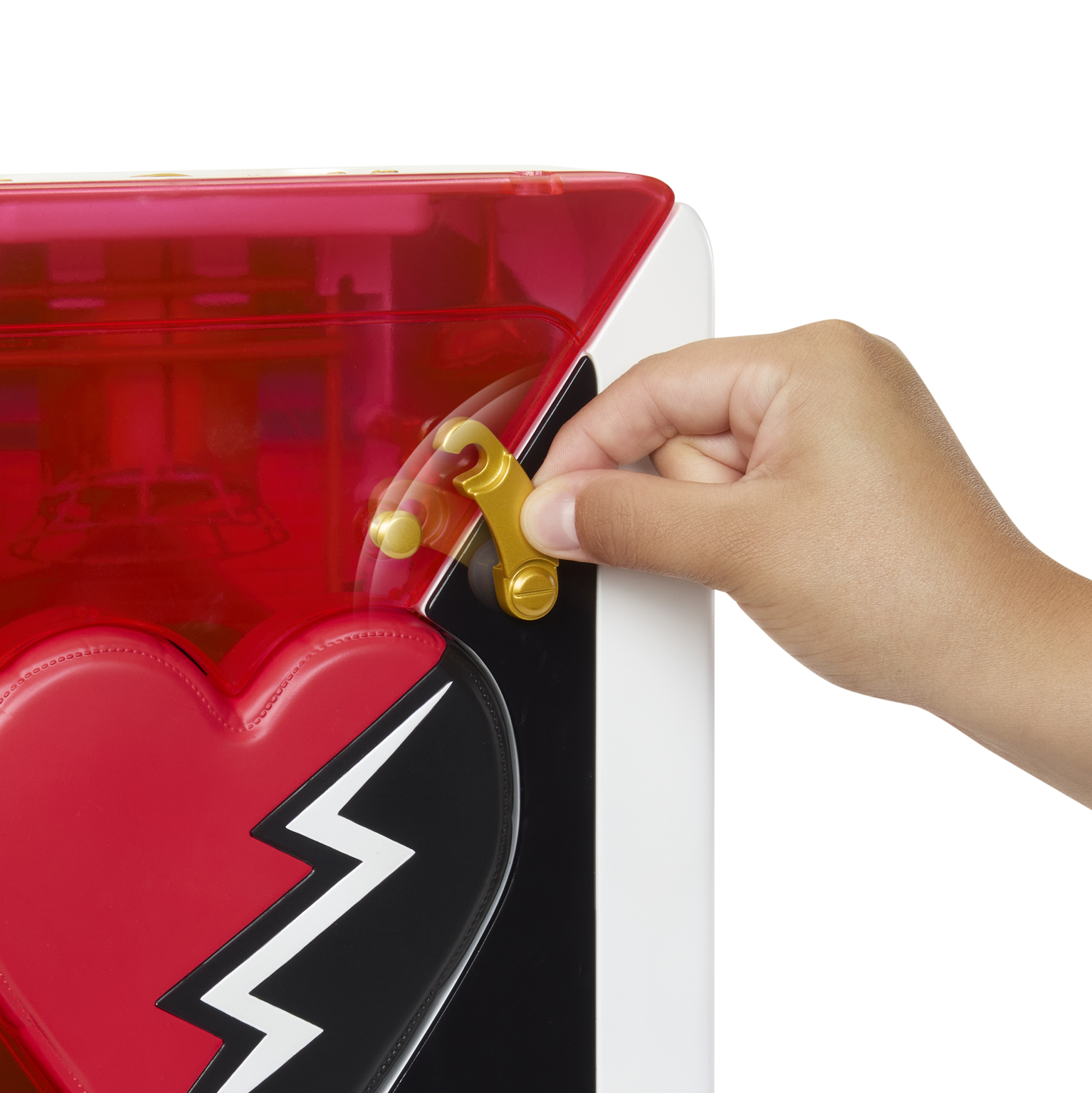 Dłoń otwiera etui z czerwonym sercem. Walizka jest czerwona i złota. Dłoń jest brązowa.