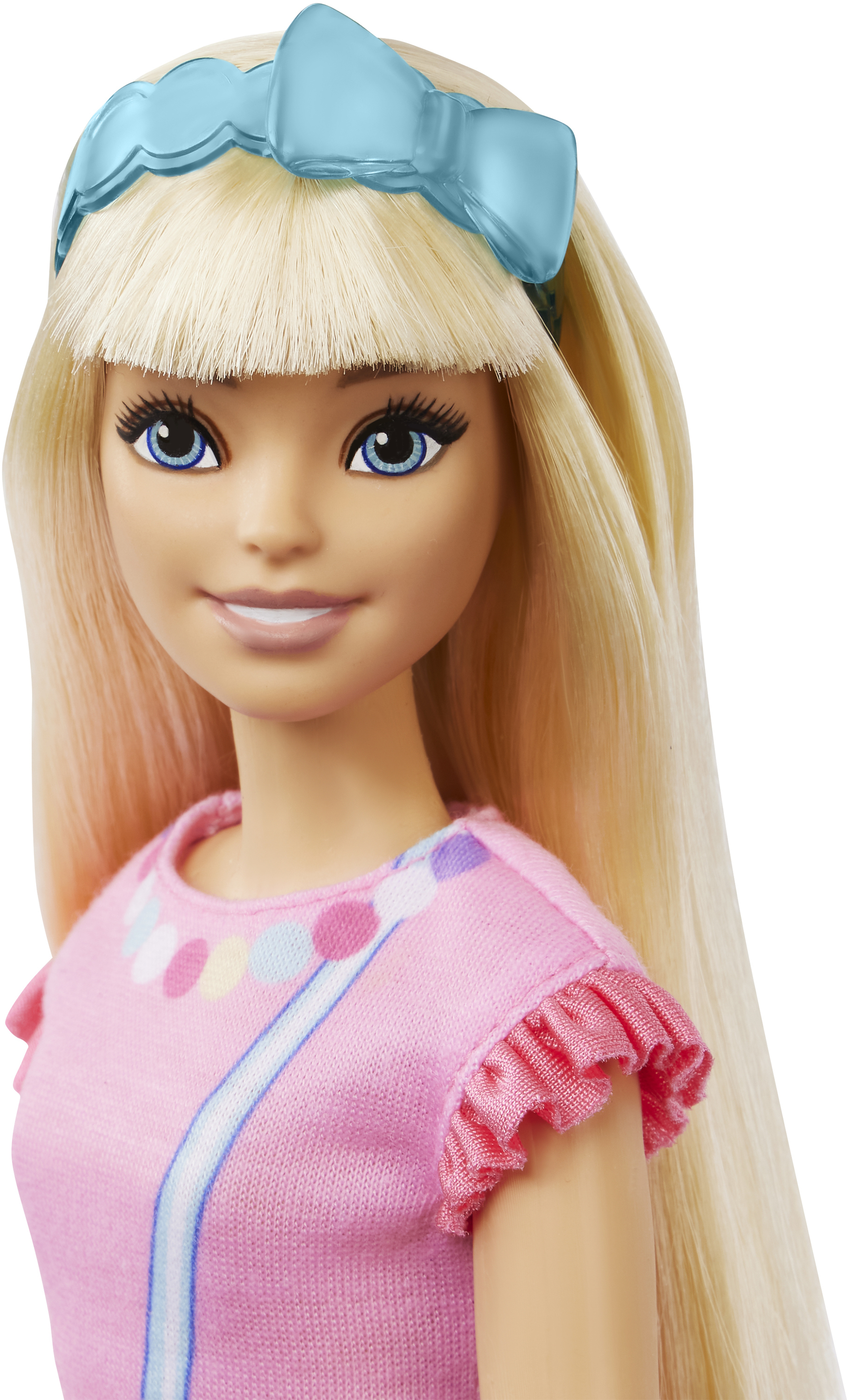 Eine Barbie-Puppe mit blondem Haar, blauen Augen und einem rosa Kleid. Sie hat ein blaues Stirnband und lächelt.