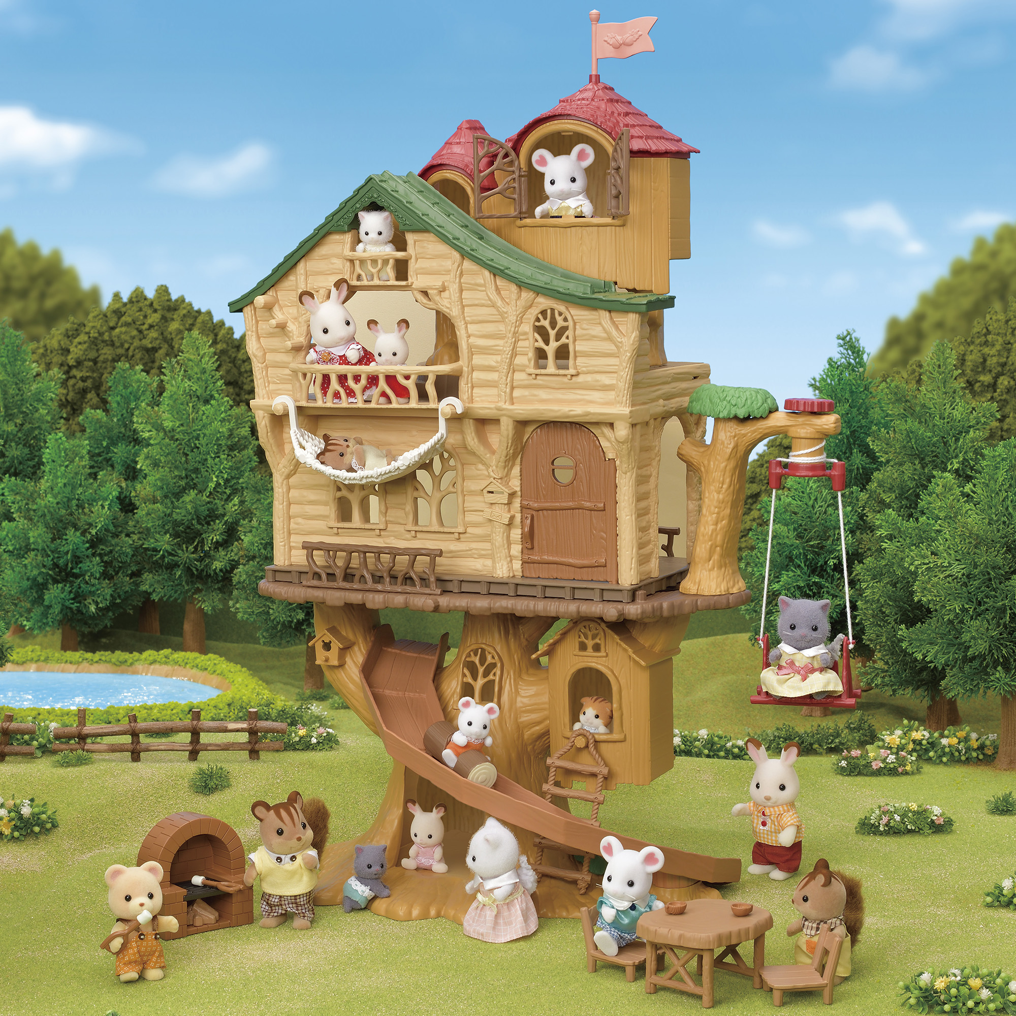 Una casa en el árbol con figuras de animales de juguete, incluyendo ratones y ardillas. La escena se desarrolla en un paisaje verde con un estanque y árboles.