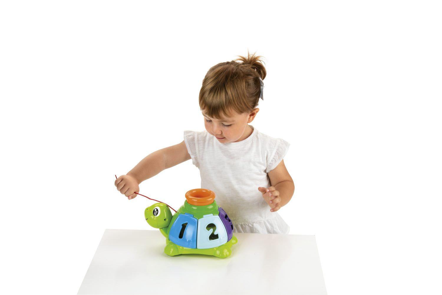 Un bambino gioca con un giocattolo a forma di tartaruga, tirando un filo. Il giocattolo ha numeri e colori. Sfondo bianco.