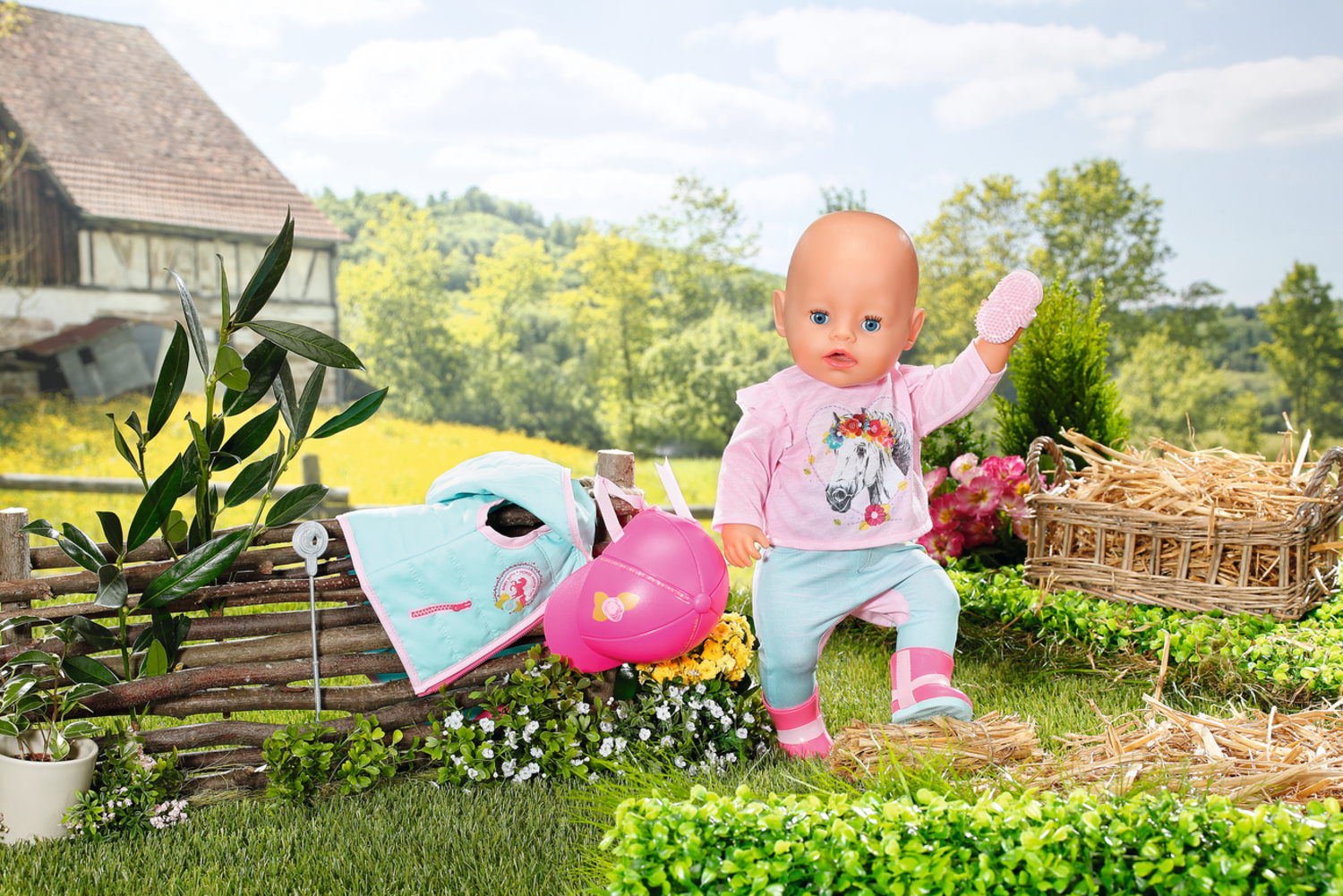 Lalka w butach i różowej koszuli, trzymająca rękawicę. Tło obejmuje stodołę, płot, kapelusz i kosz siana.