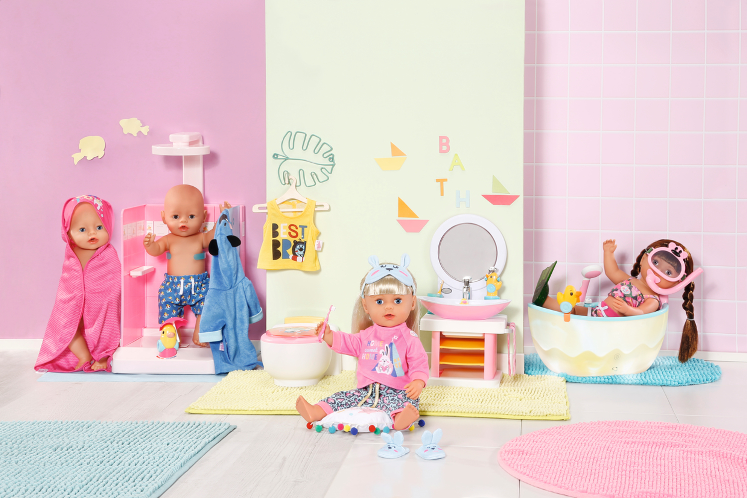 Bambole in una scena del bagno. Una in una vasca con un boccaglio, altre con asciugamani e vestiti. Lavandino, toilette e altri accessori sono presenti.