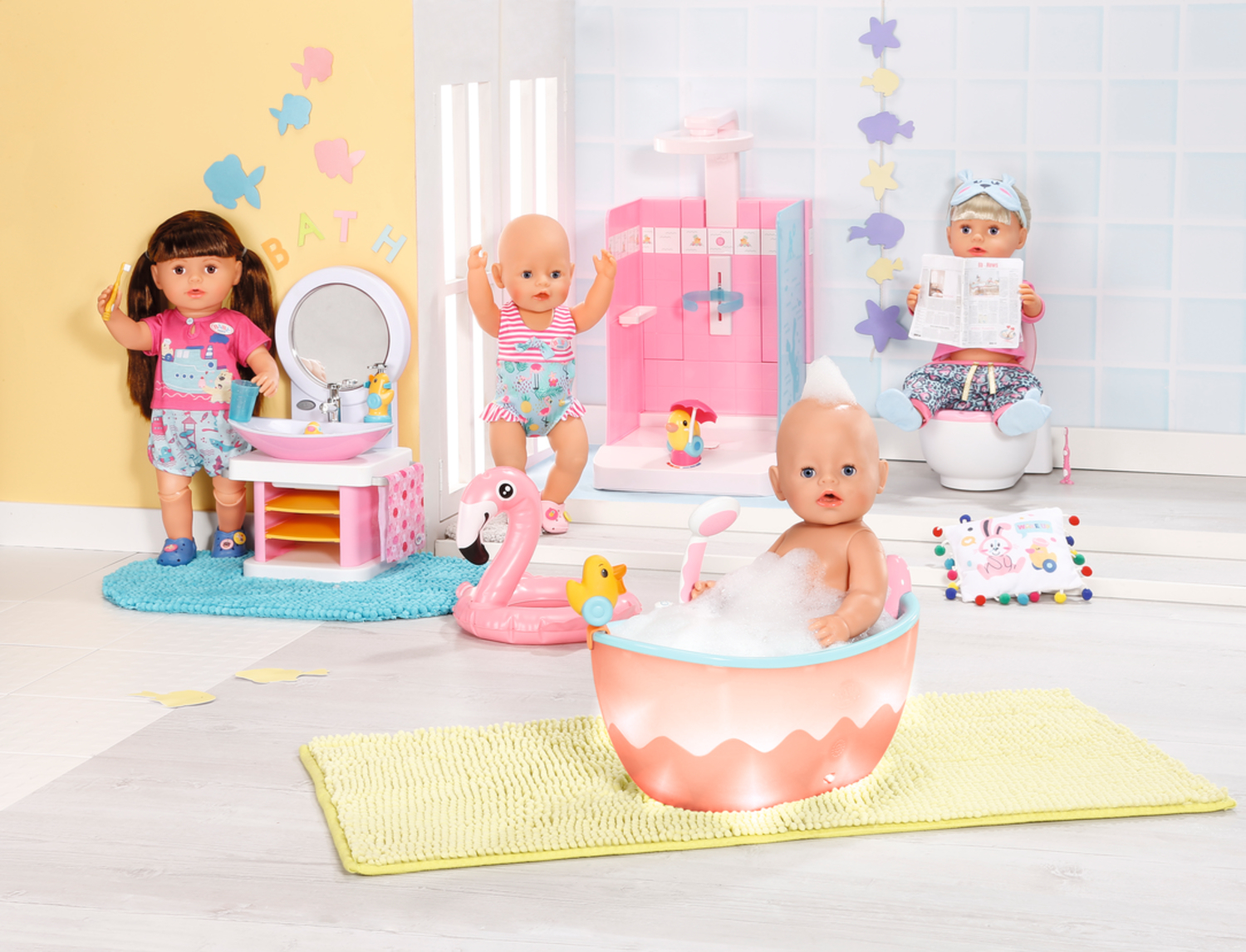 Una scena di bagno con bambole. Una bambola si lava i denti. Un'altra è in piedi. Una terza fa il bagno. C'è una doccia rosa e un fenicottero.