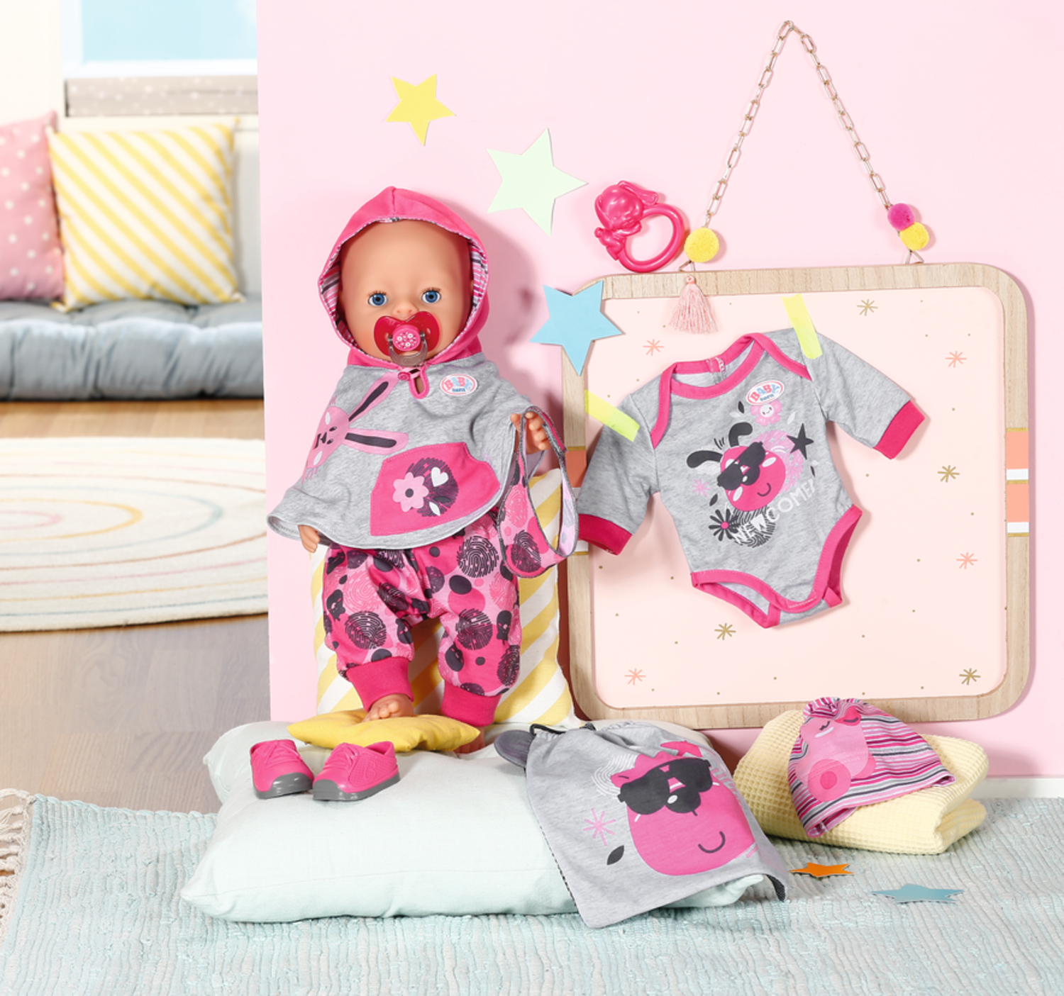 Eine Puppe in rosa-grauer Kleidung mit passenden Schuhen und Accessoires, die auf einem rosa Hintergrund mit Spielzeug ausgestellt ist.