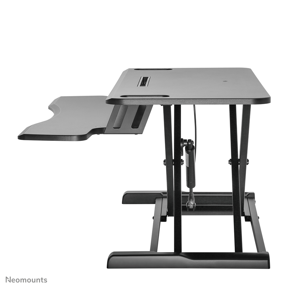 Ein schwarzer, verstellbarer Schreibtisch mit Seitenerweiterung. Er hat eine rechteckige Oberseite, unterstützt von schwarzen Metallbeinen.