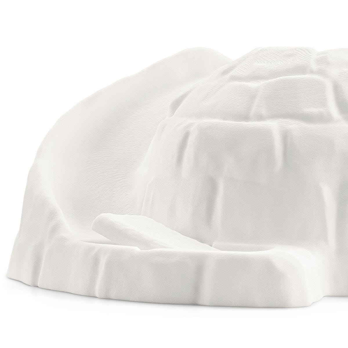 Un modèle d'igloo blanc. Le dôme a une surface texturée avec des motifs de briques simulés. Une rampe mène à l'entrée.