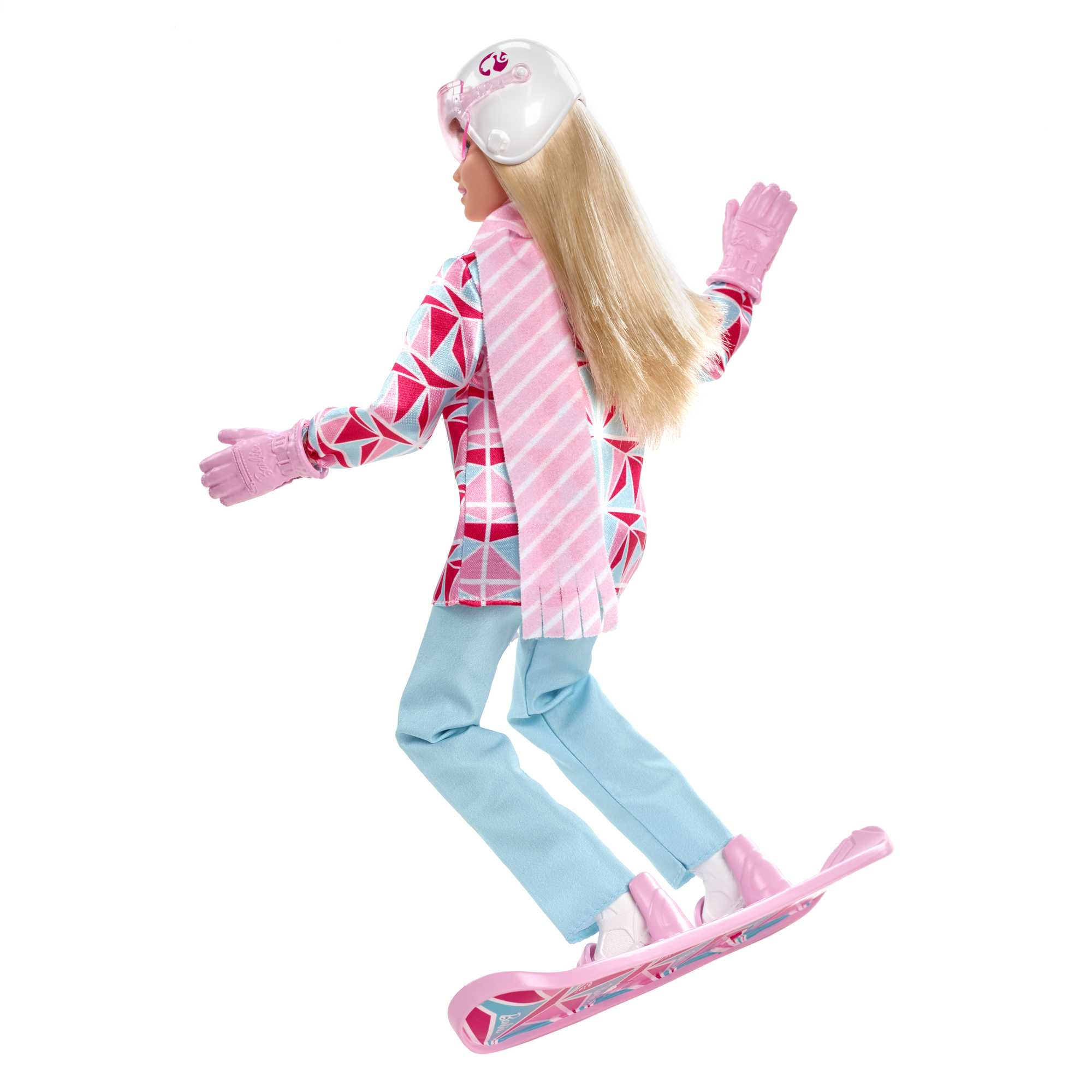 Lalka Barbie w zimowym stroju na snowboardzie. Ma różowe rękawiczki, kask i szalik. Snowboard jest różowy.