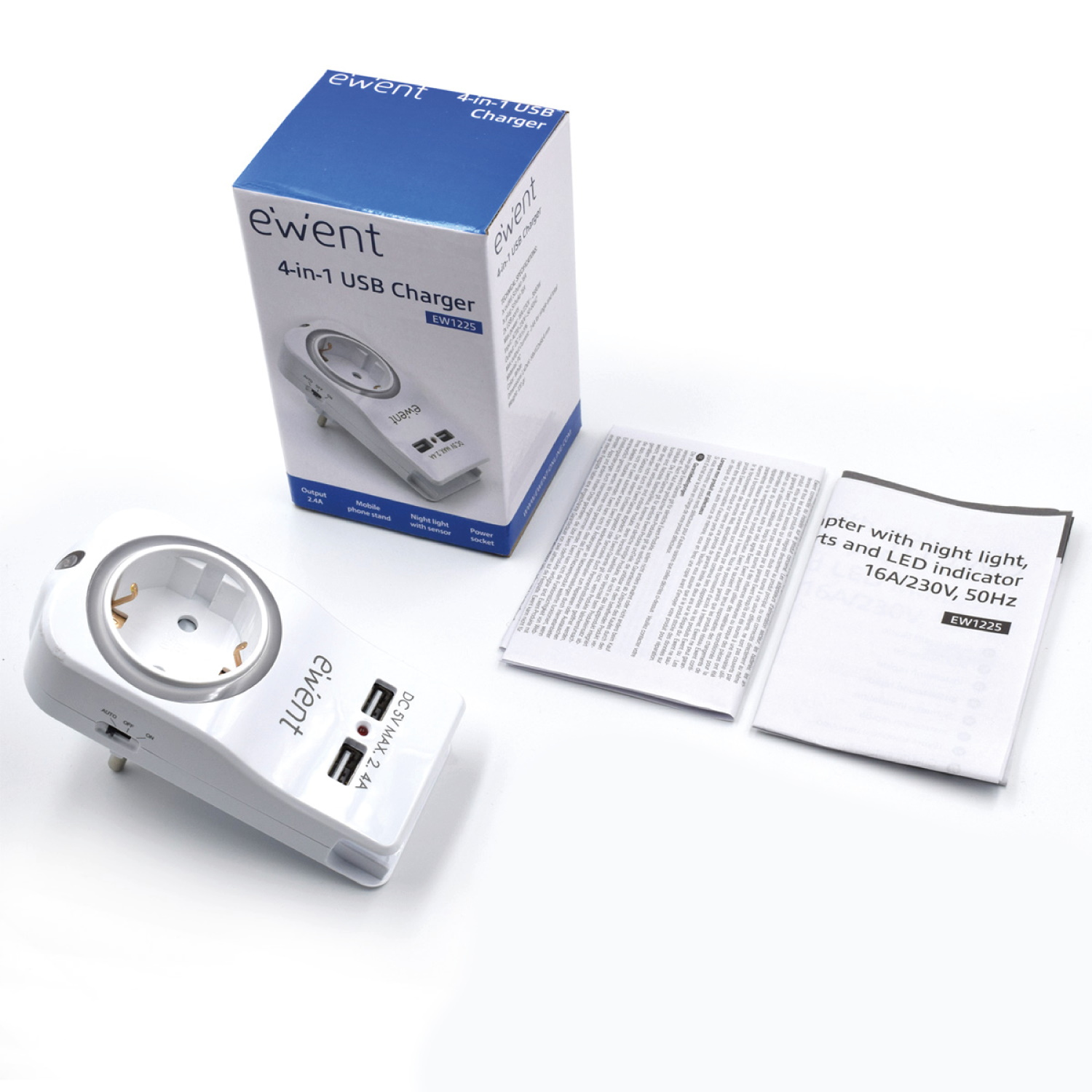 Adaptador de corriente blanco, caja y manuales sobre una superficie blanca. El adaptador tiene enchufes y puertos USB.